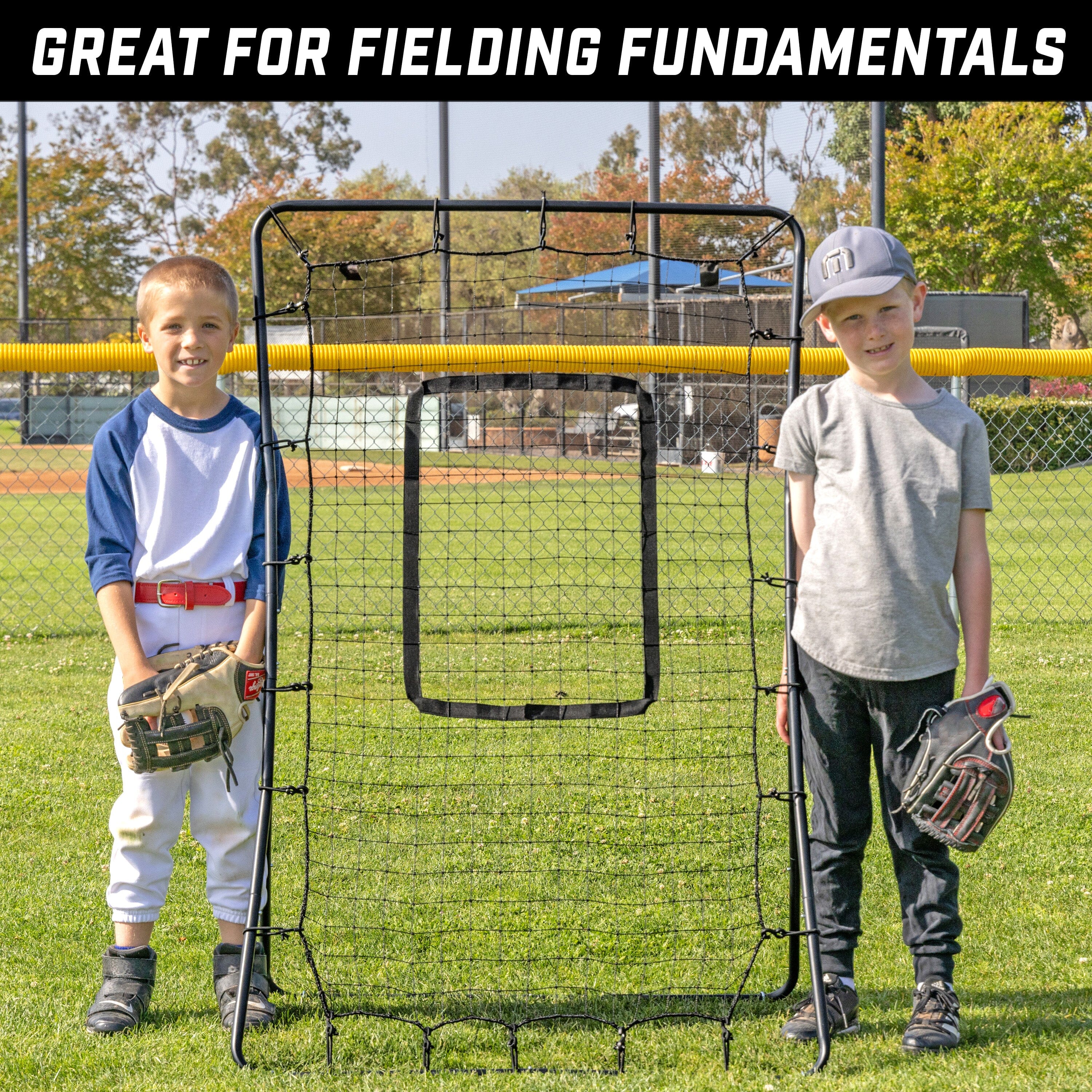 two young boys standing in front of a batting cage