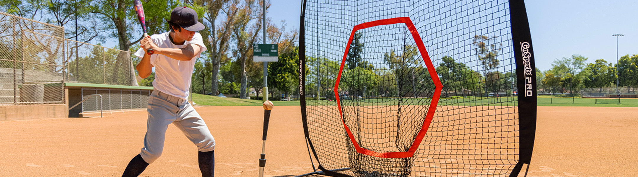 Person practicing baseball with a net on a field