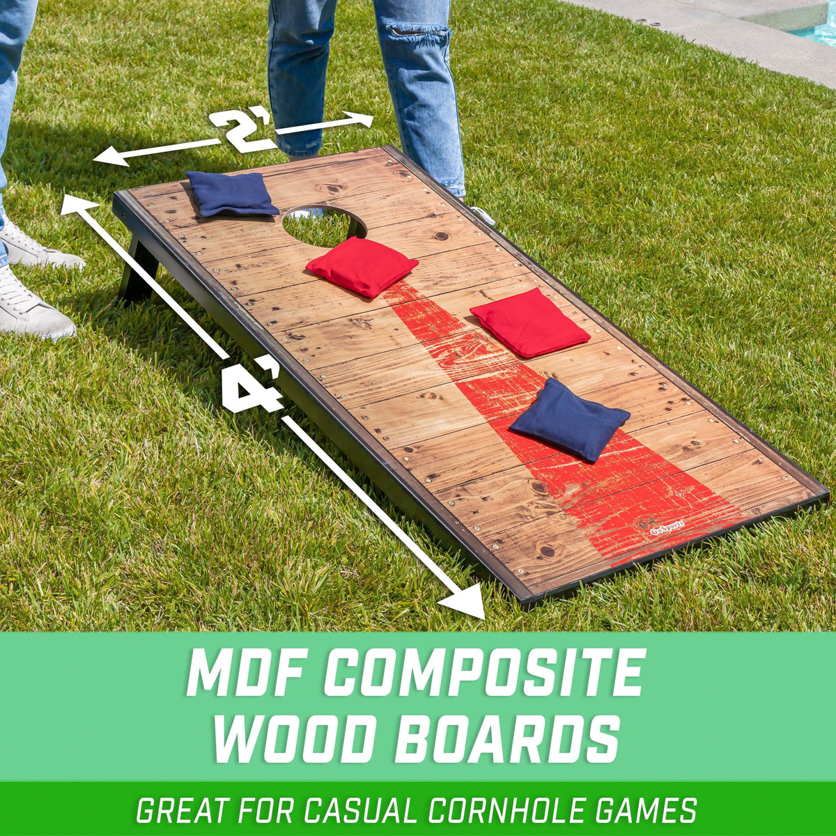 Rustic wood GoSports cornhole board with red stripe & black frame on grass, 4x2 ft arrows & 4 bags