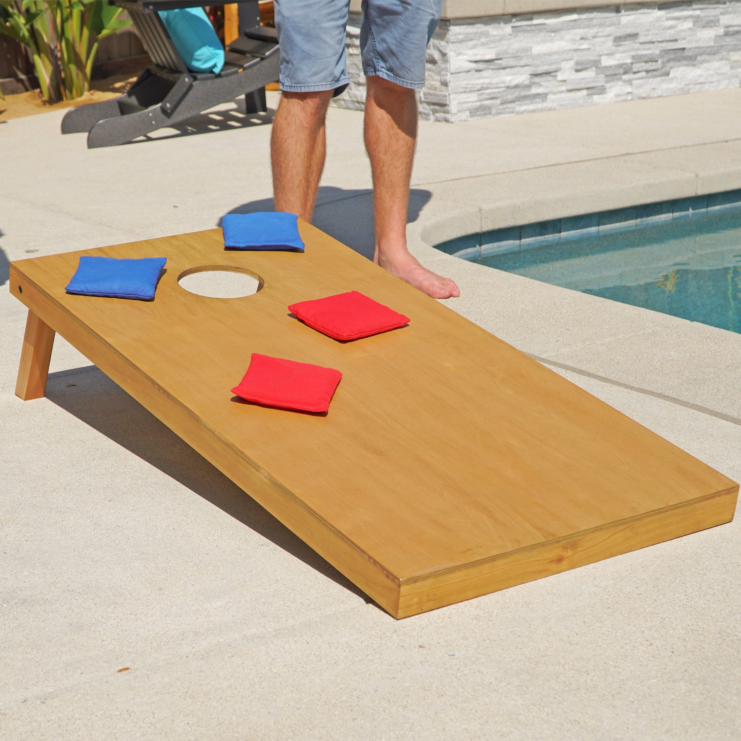 a man standing next to a pool with a wooden board