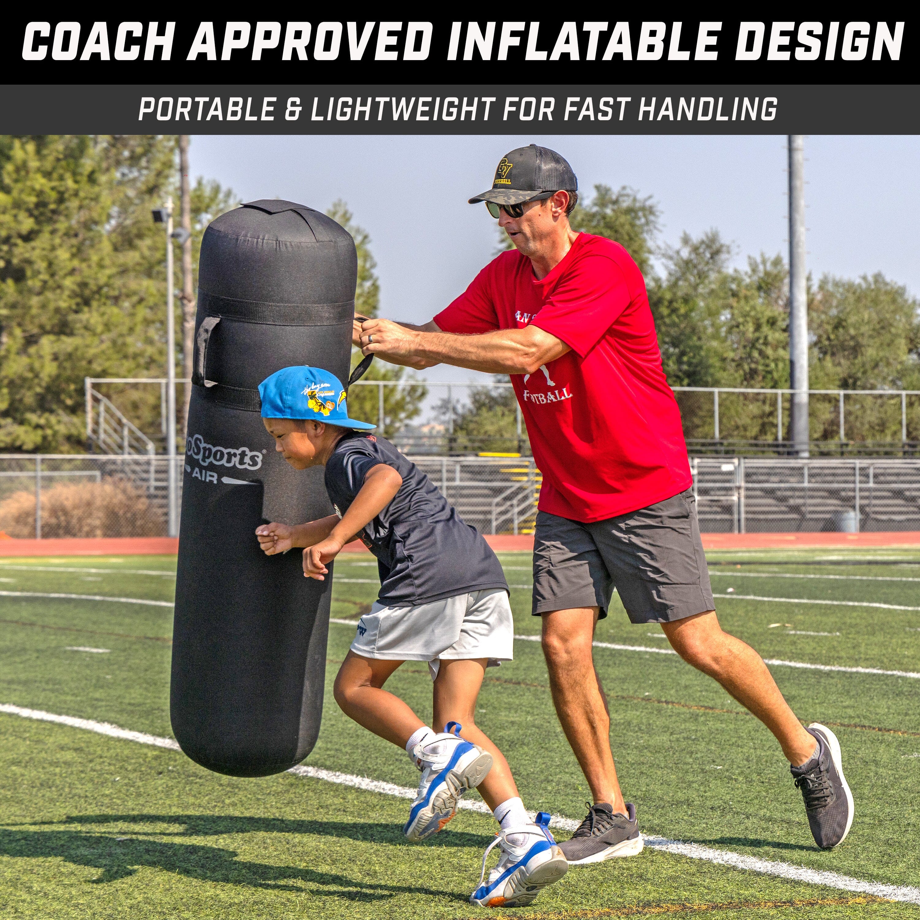 child trying to tackle inflatable being held by a man