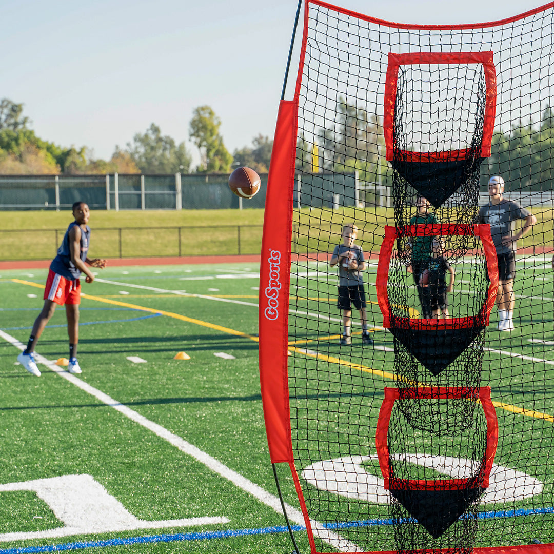 Sports training net with a basketball hoop on a sports field, featuring GoSports branding.