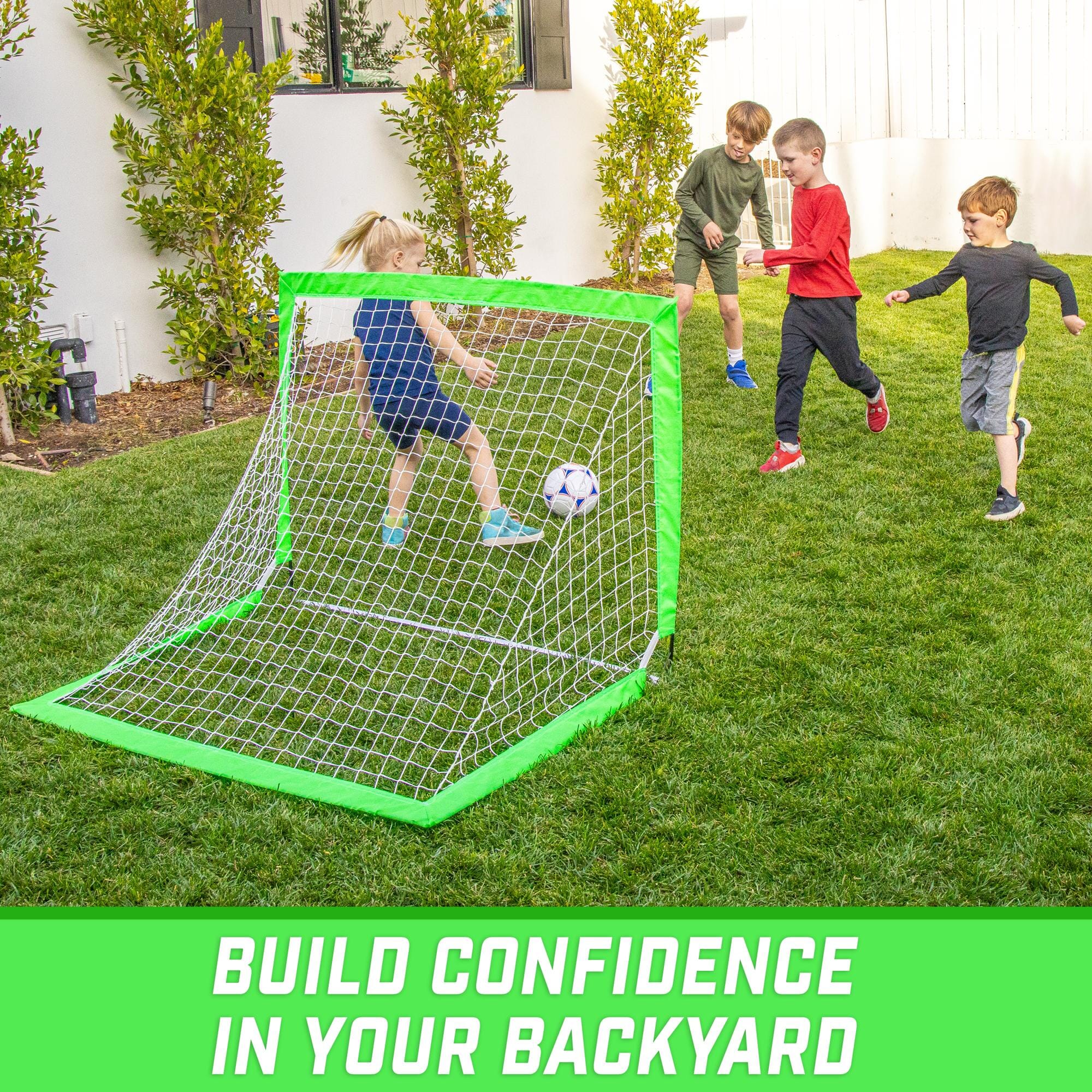 a backyard soccer goal with two kids playing in it
