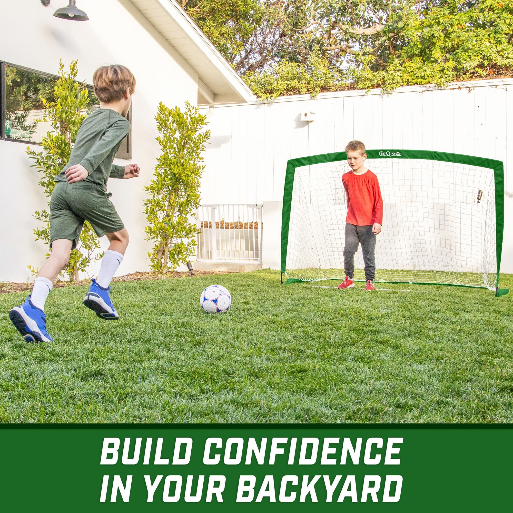 a young boy kicking a soccer ball in the yard