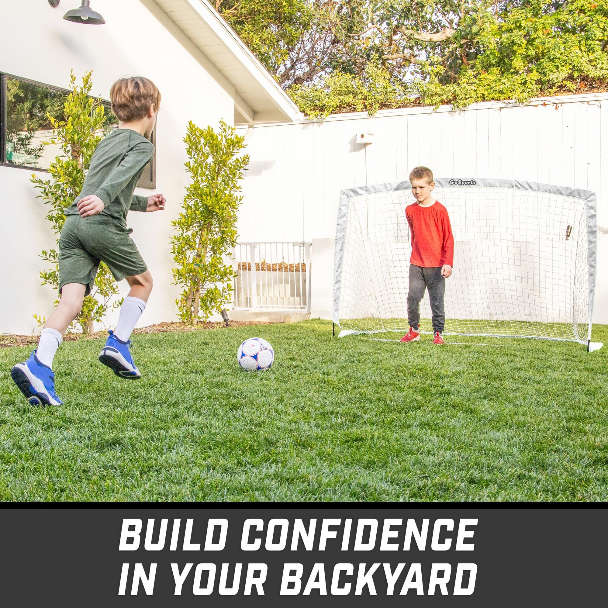 a young boy kicking a soccer ball in the yard