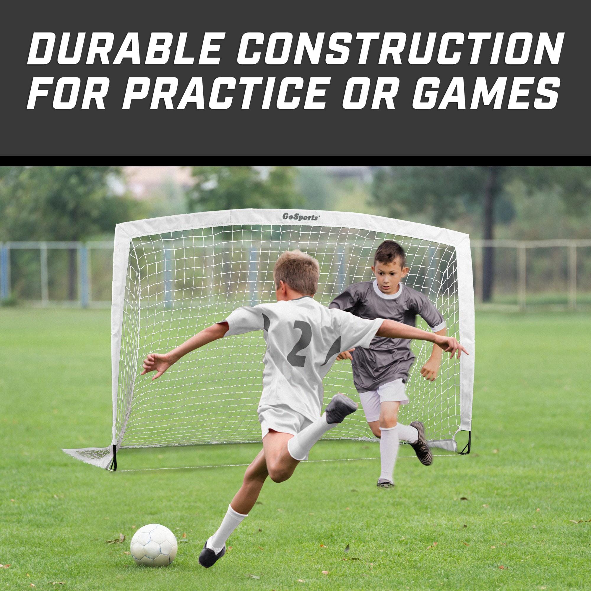 a young boy kicking a soccer ball on a field