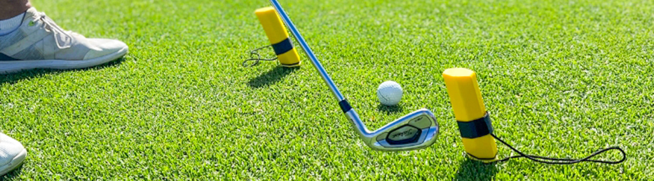 yellow pylons on green grass next to golf club