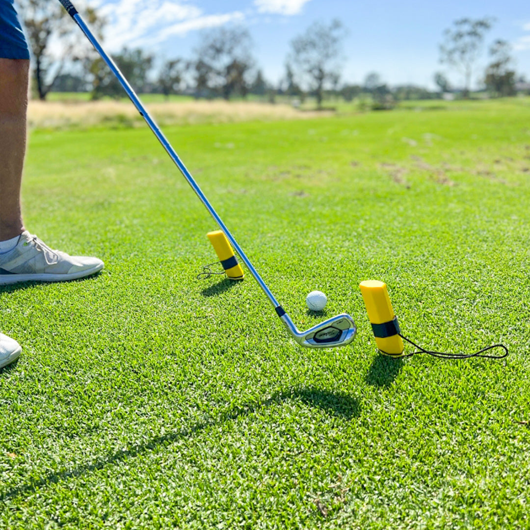 Golf club and ball on a green grass field with a clear sky