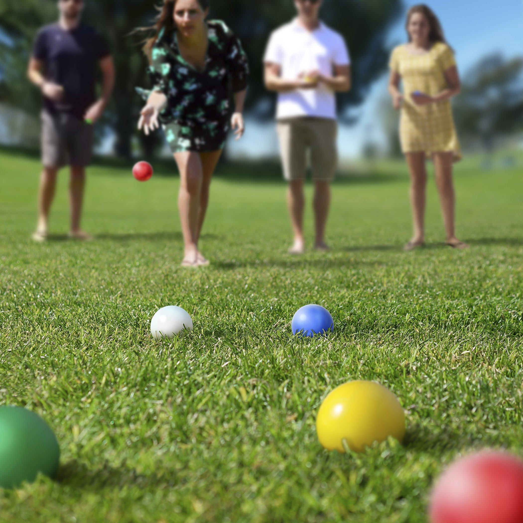 a group of people playing with balls in the grass