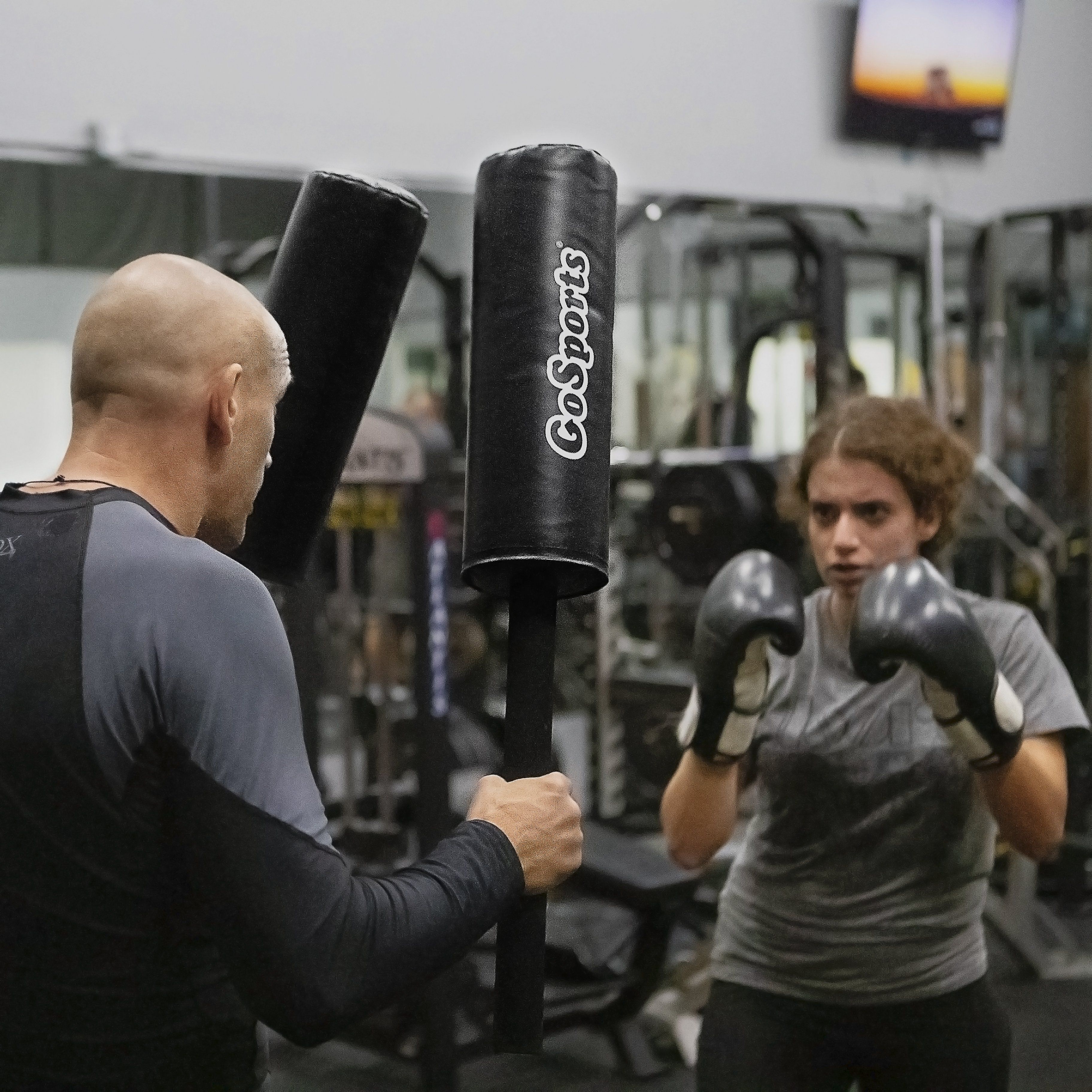 a man holding a punching bag in a gym