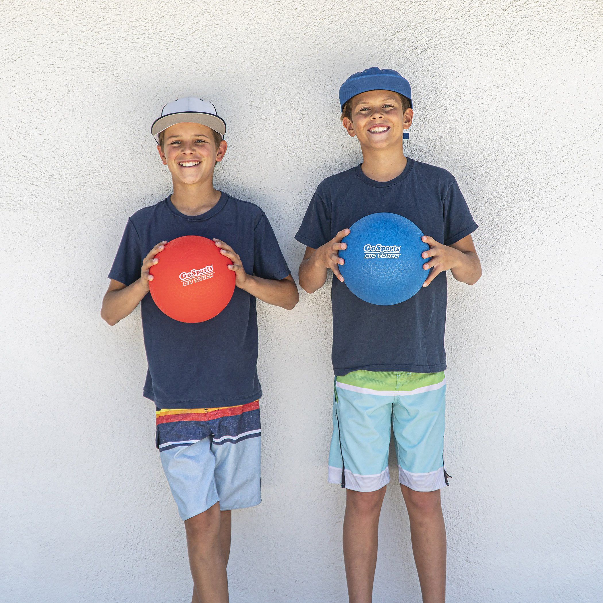 two boys holding red ball and a blue ball