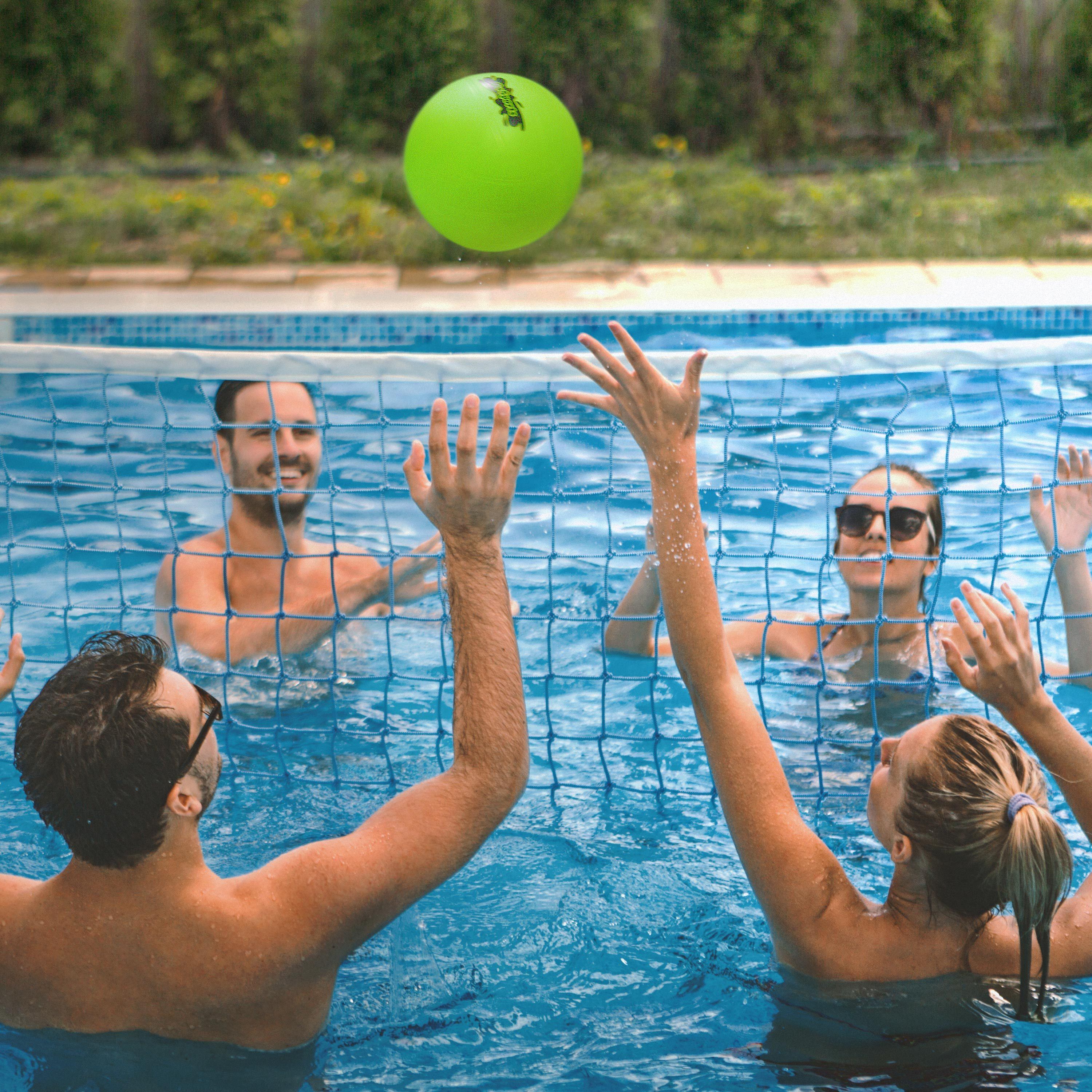 a group of people playing volleyball in a pool