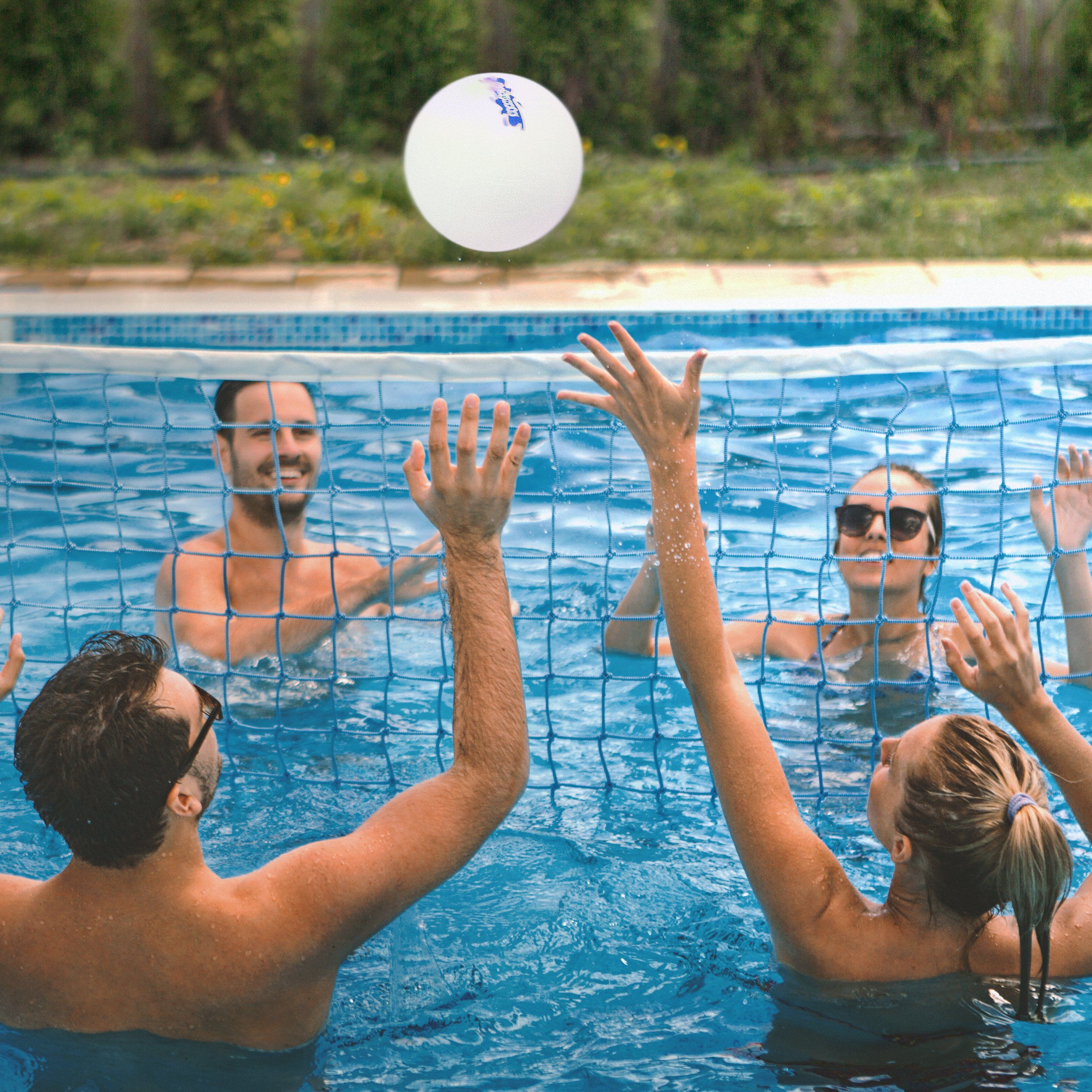 a group of people playing volleyball in a pool