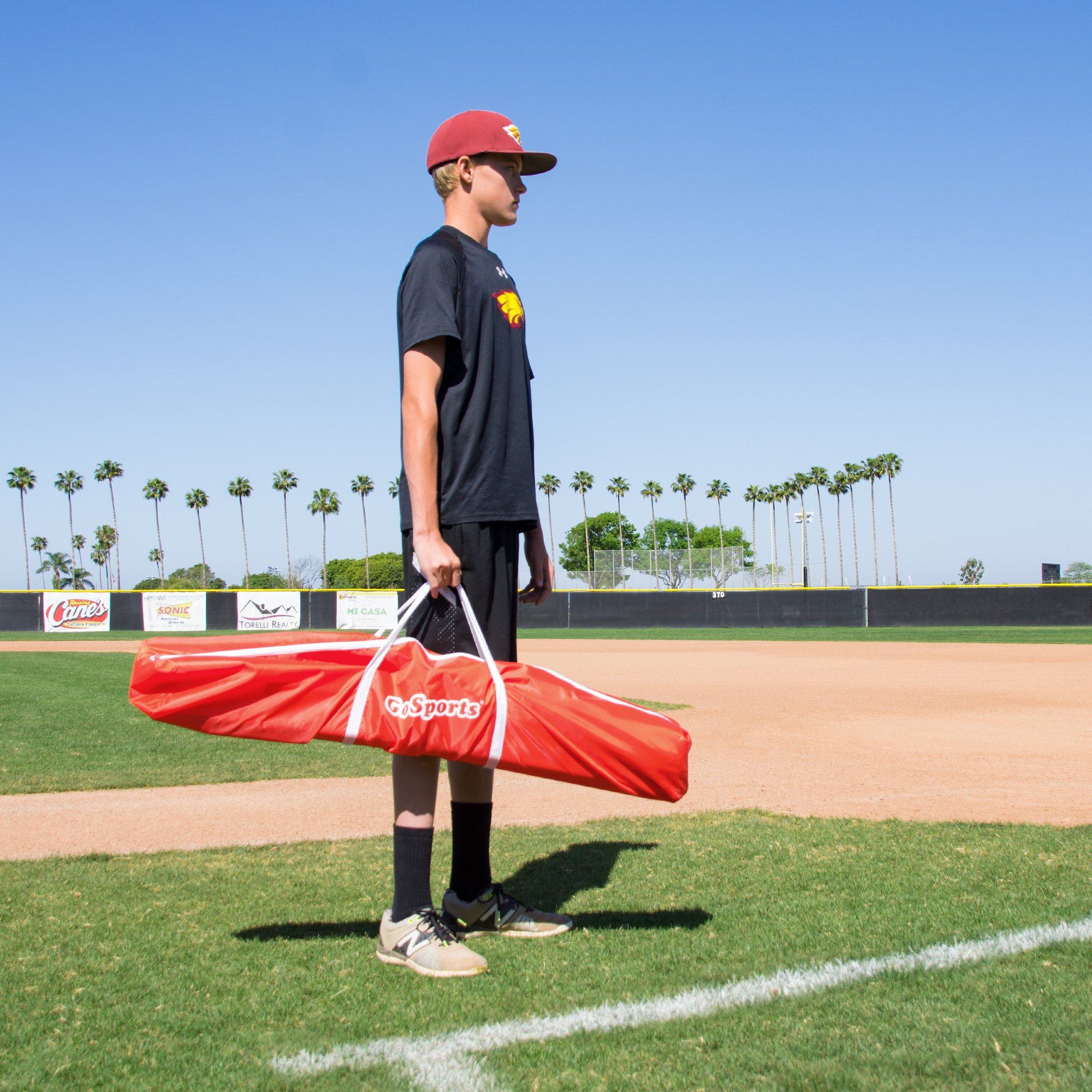 a man holding a red and white baseball bat