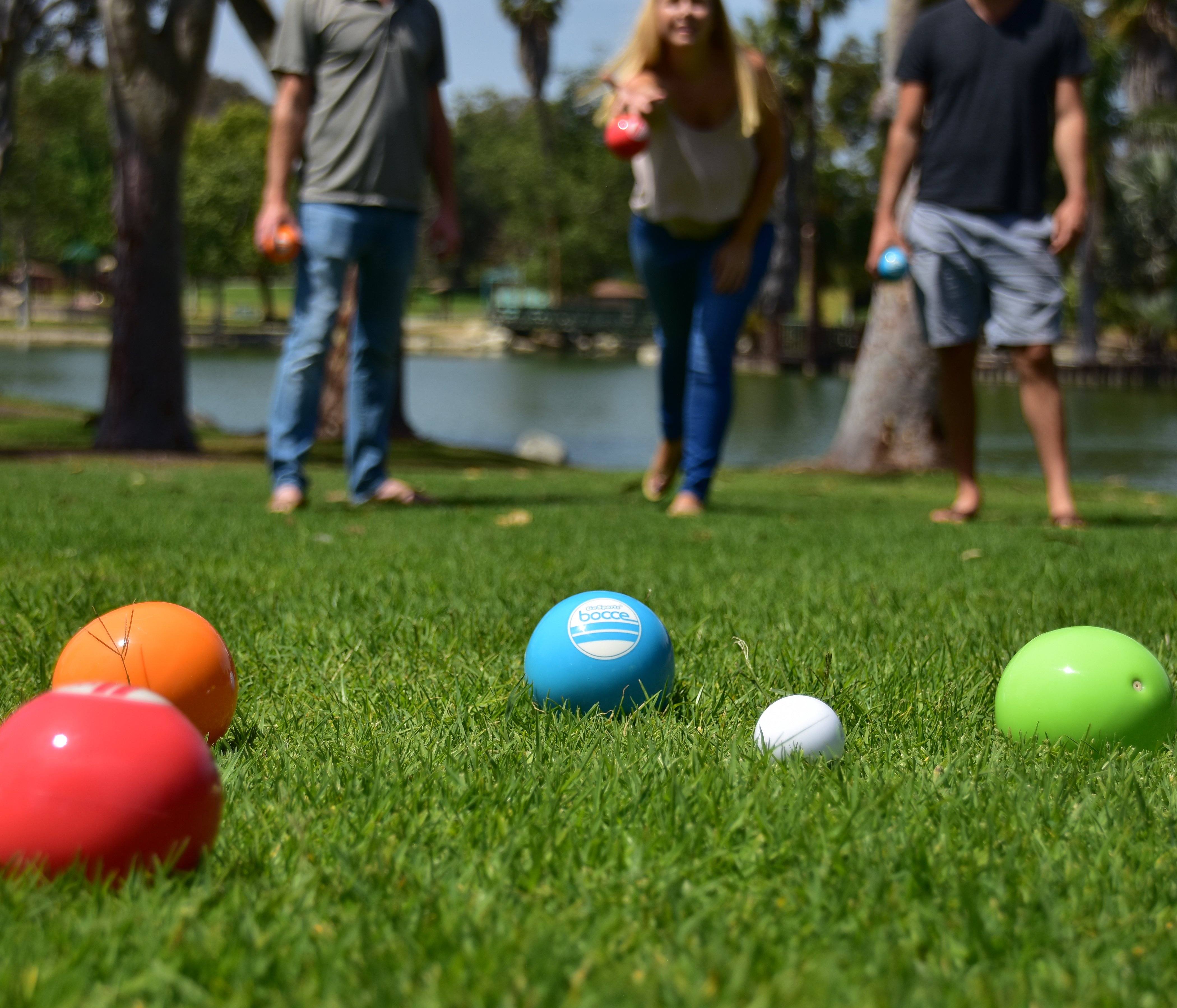 a group of people standing around a group of colorful balls
