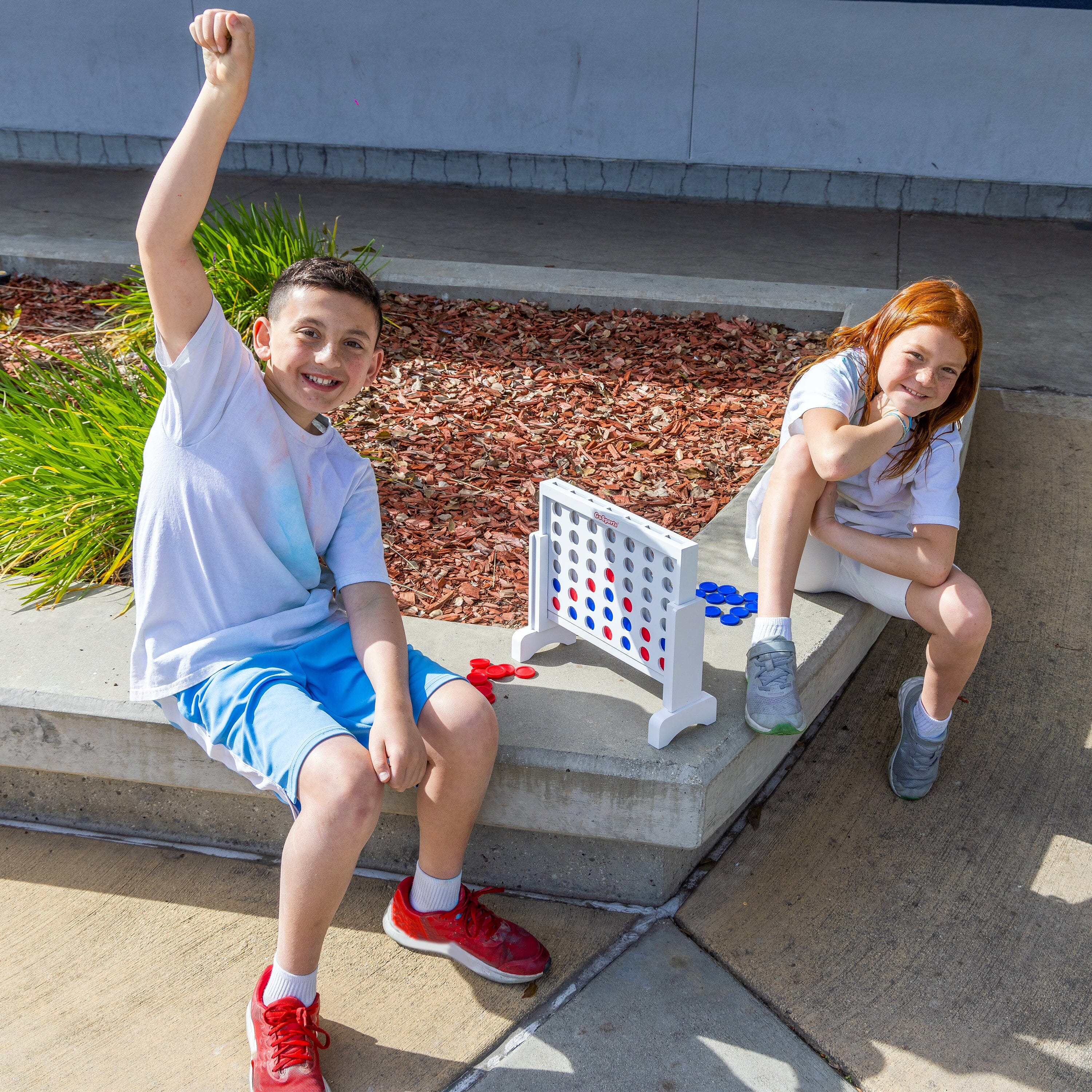 two young girls sitting on a cement bench