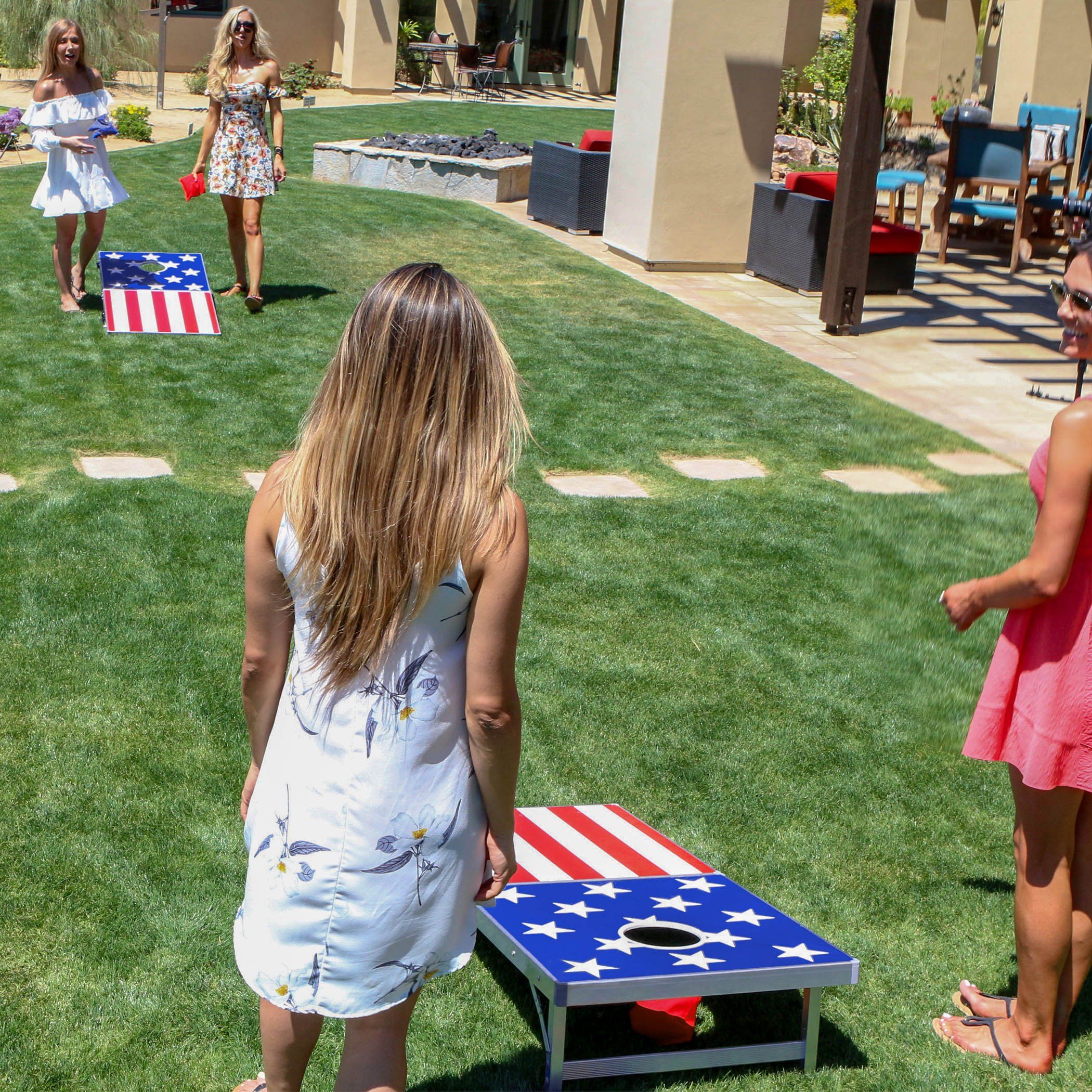 a girl in a white dress playing cornhole game