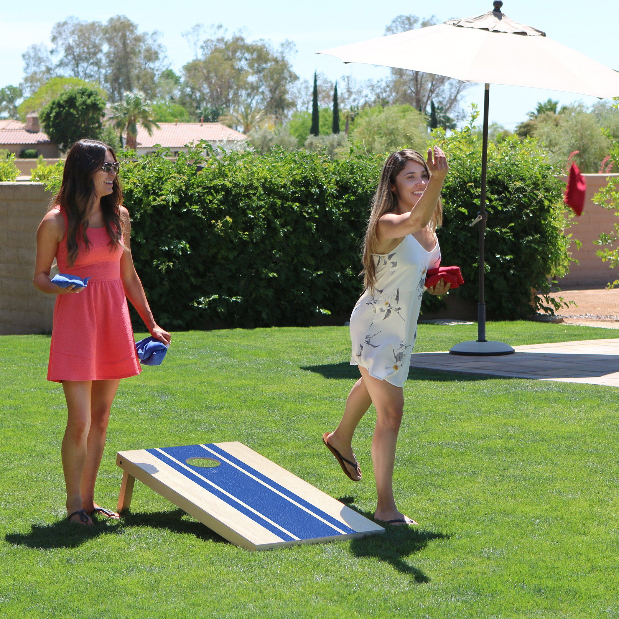 two girls playing corn corn game in the backyard