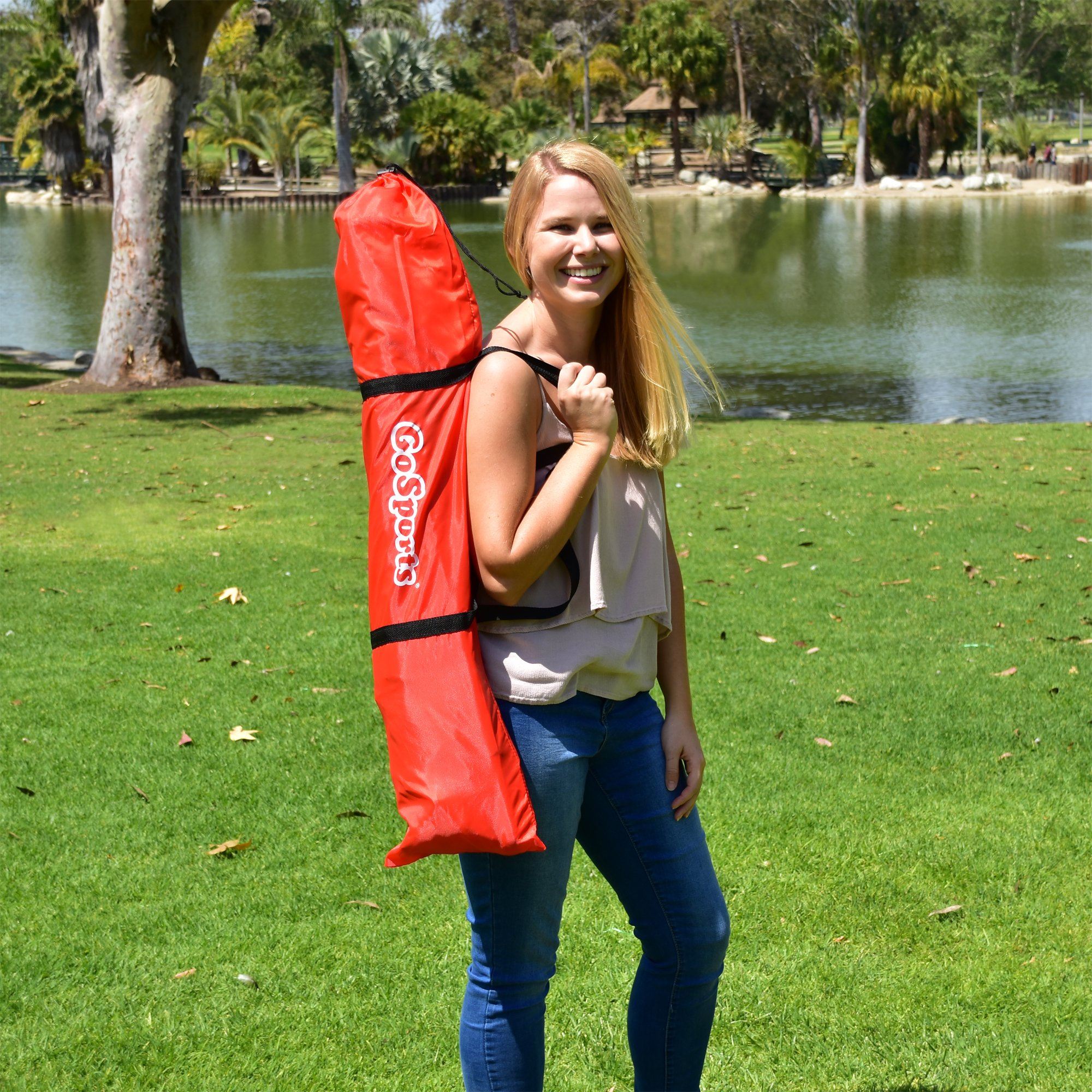 a woman holding a red bag in a park