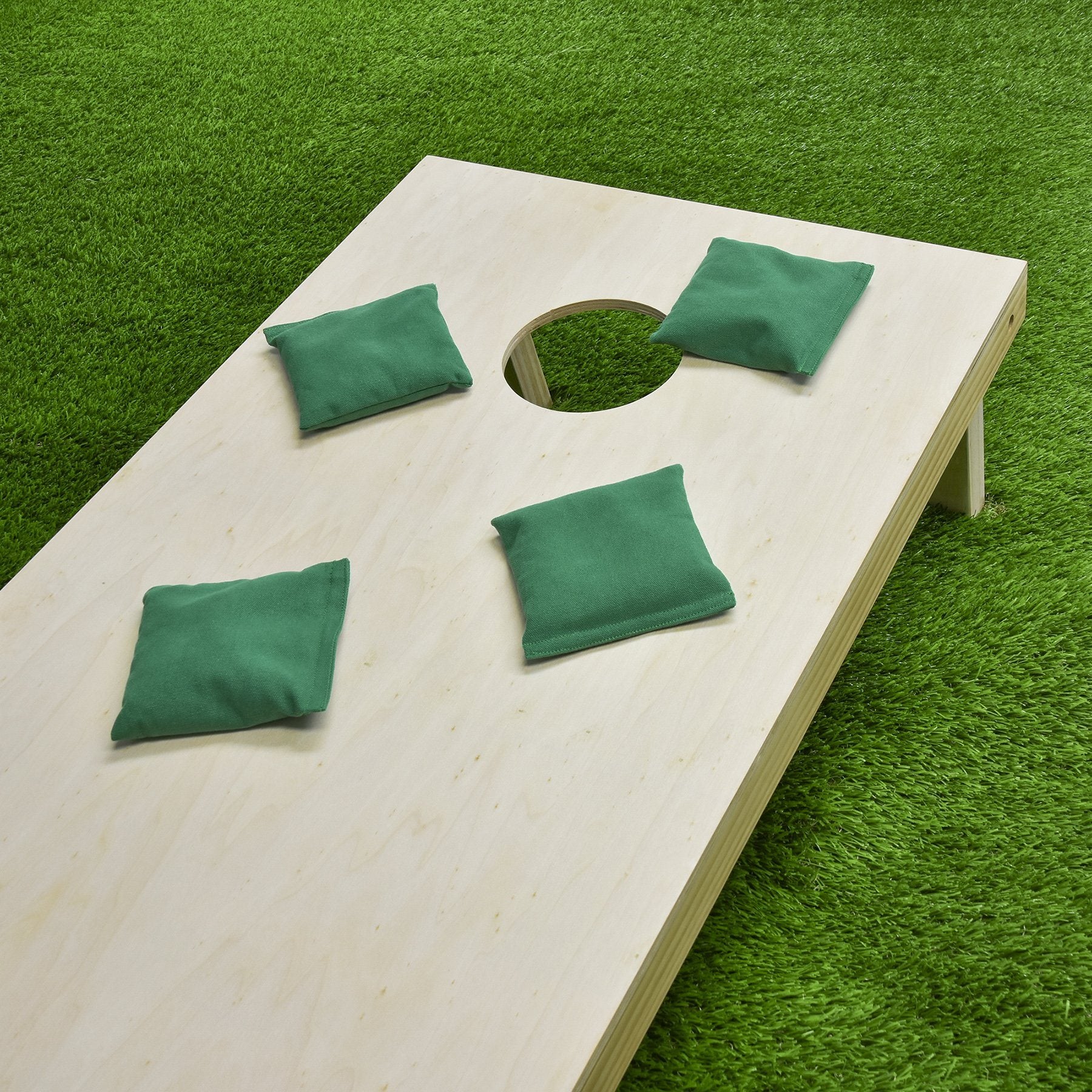 a wooden table with green cushions on it