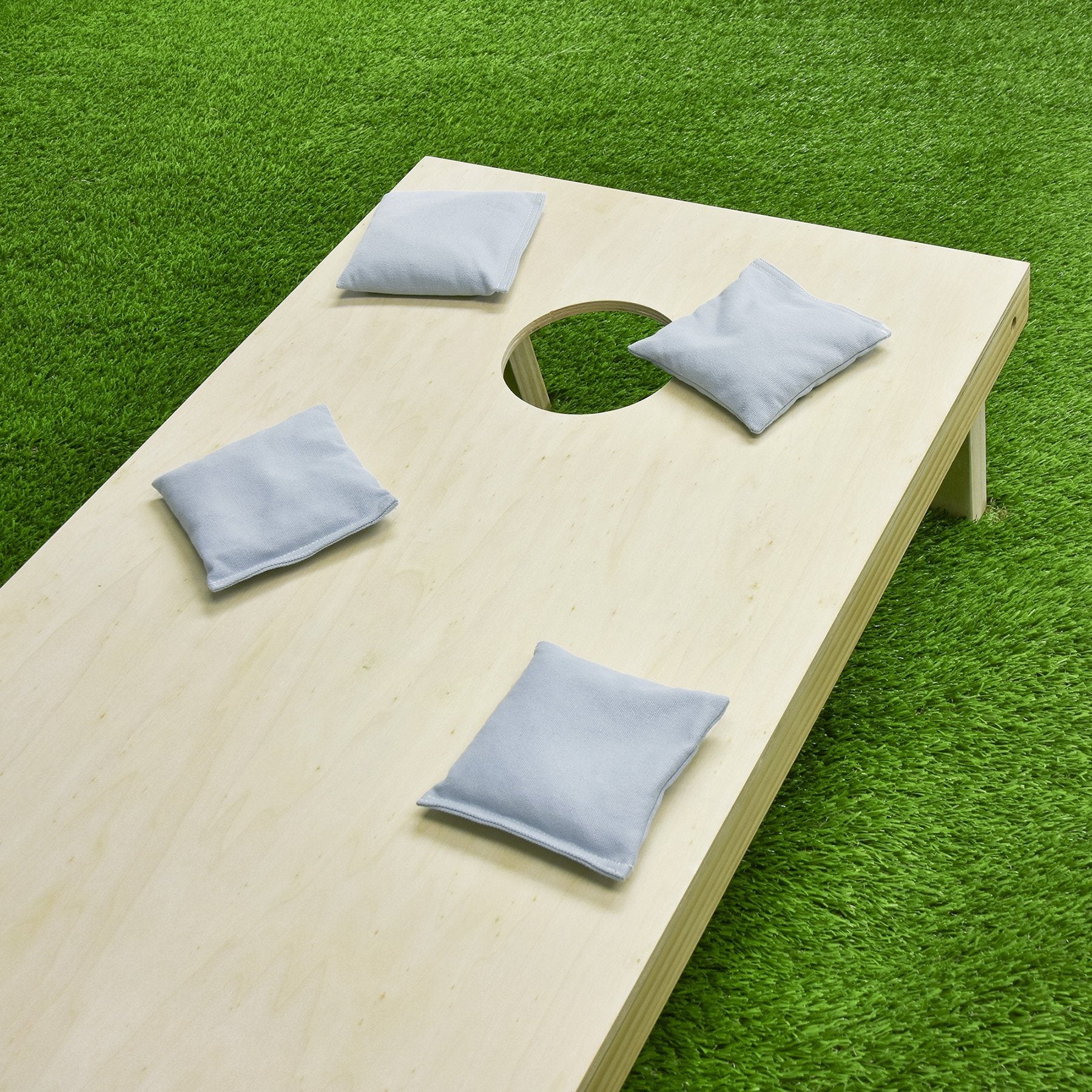a wooden cornhole with blue pillows on it