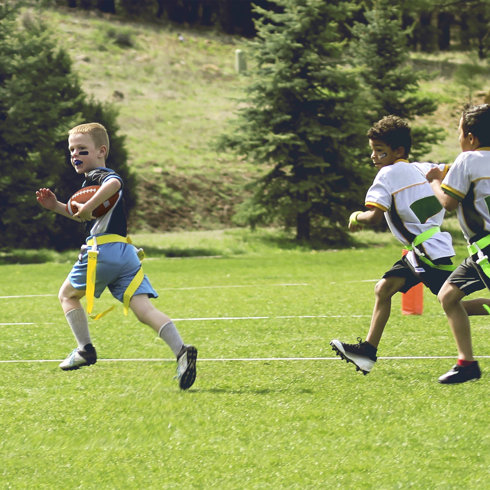 a group of young boys running across a field