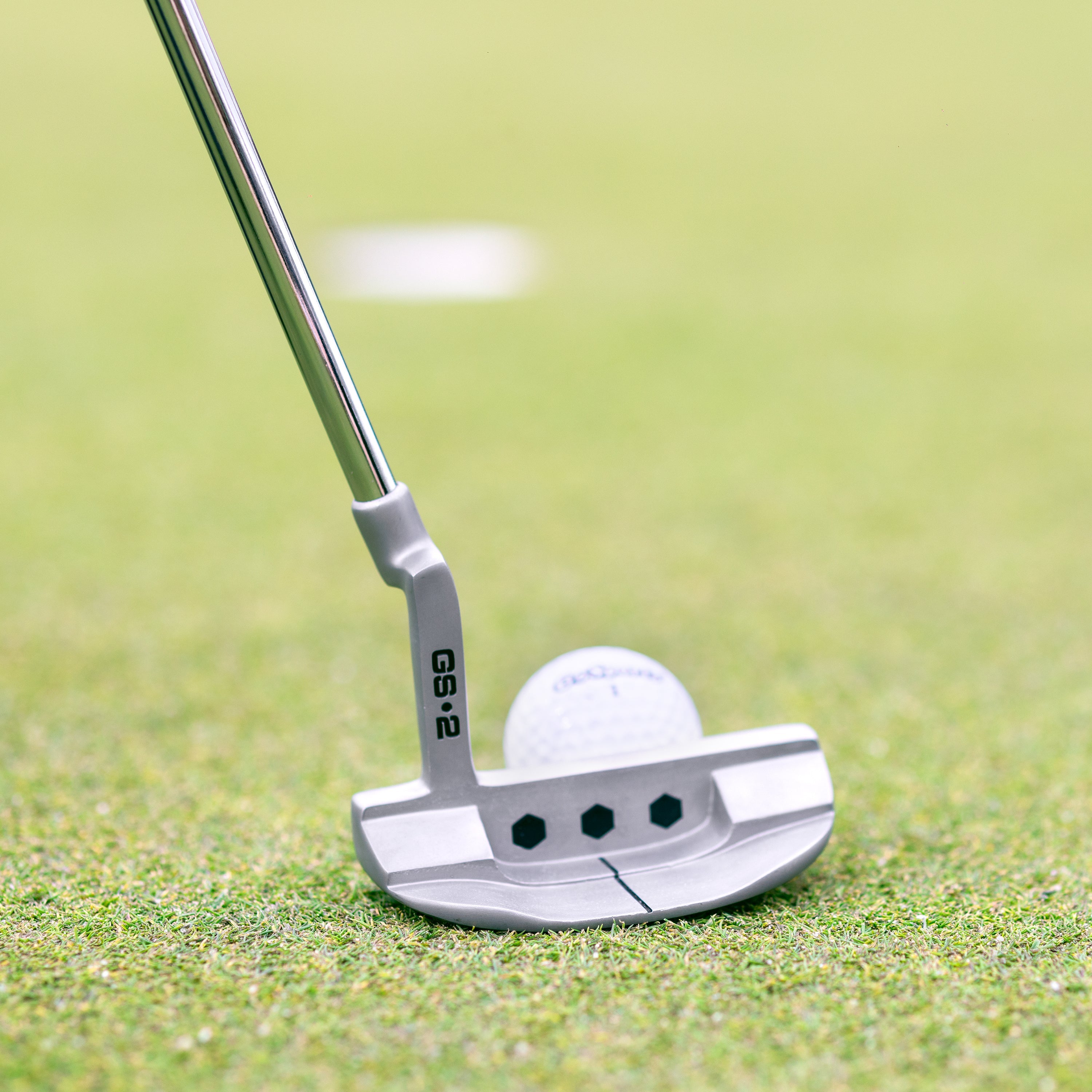 a golf ball and putter on a green