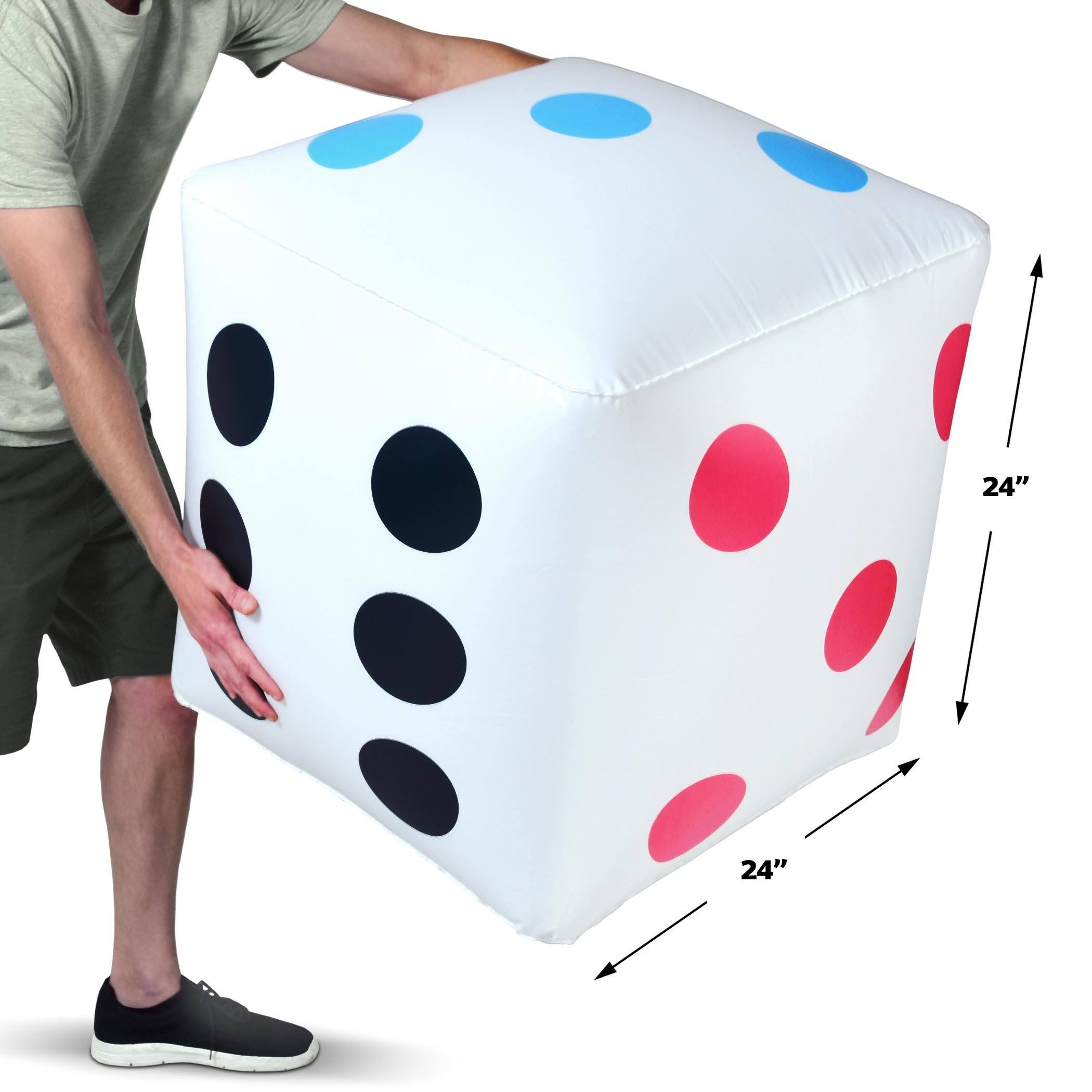 a man is holding a large white cube with red and blue spots