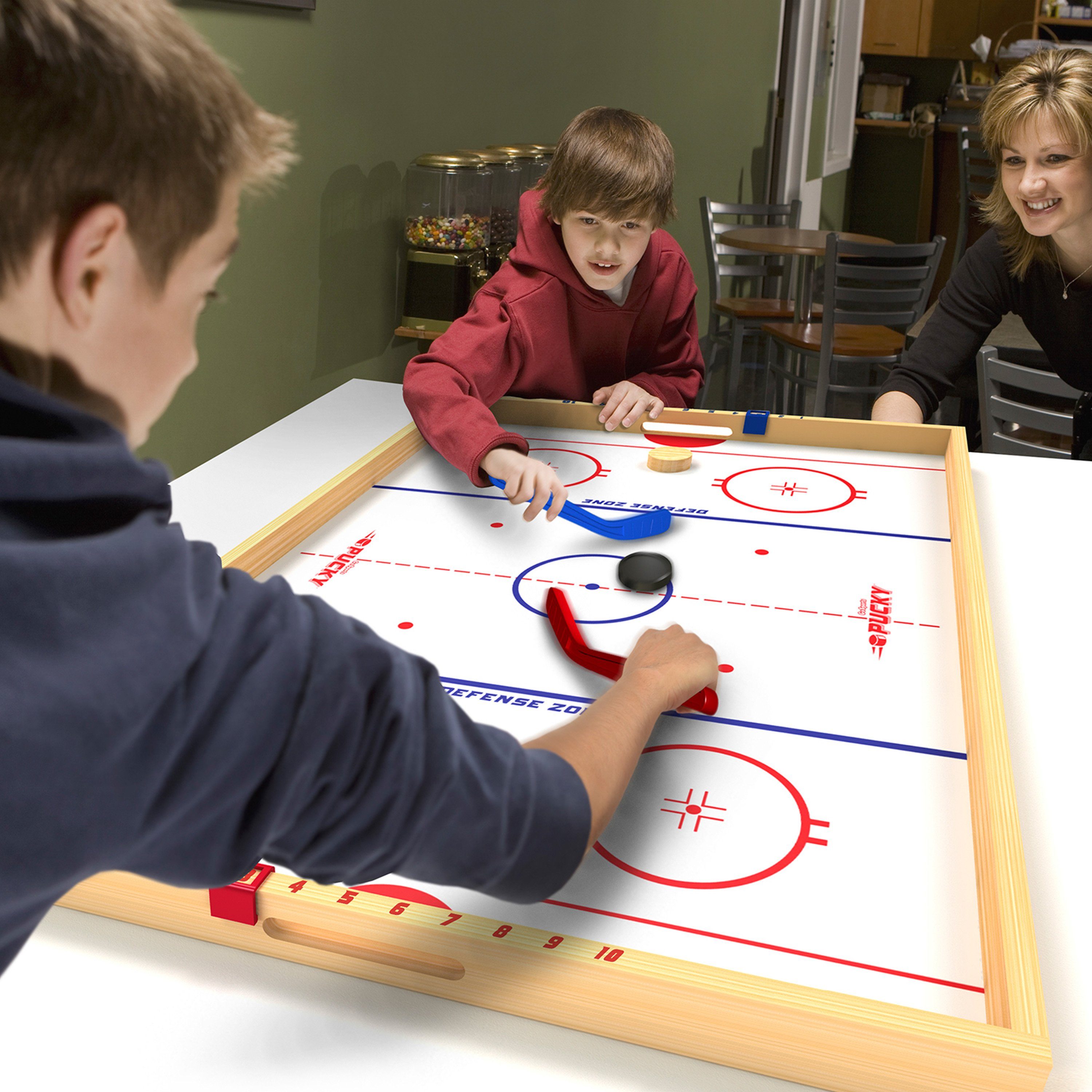 a boy playing a game of hockey with a woman
