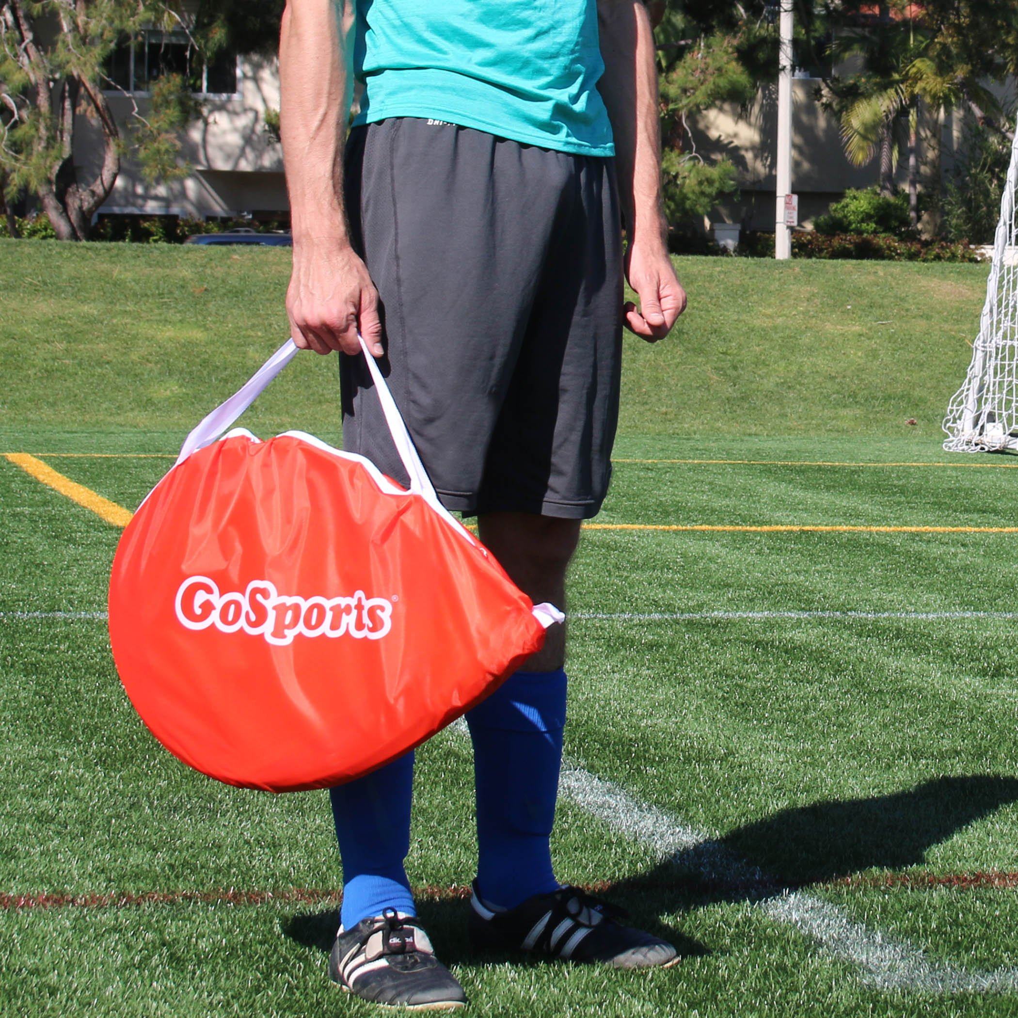 a man holding a red bag on a soccer field