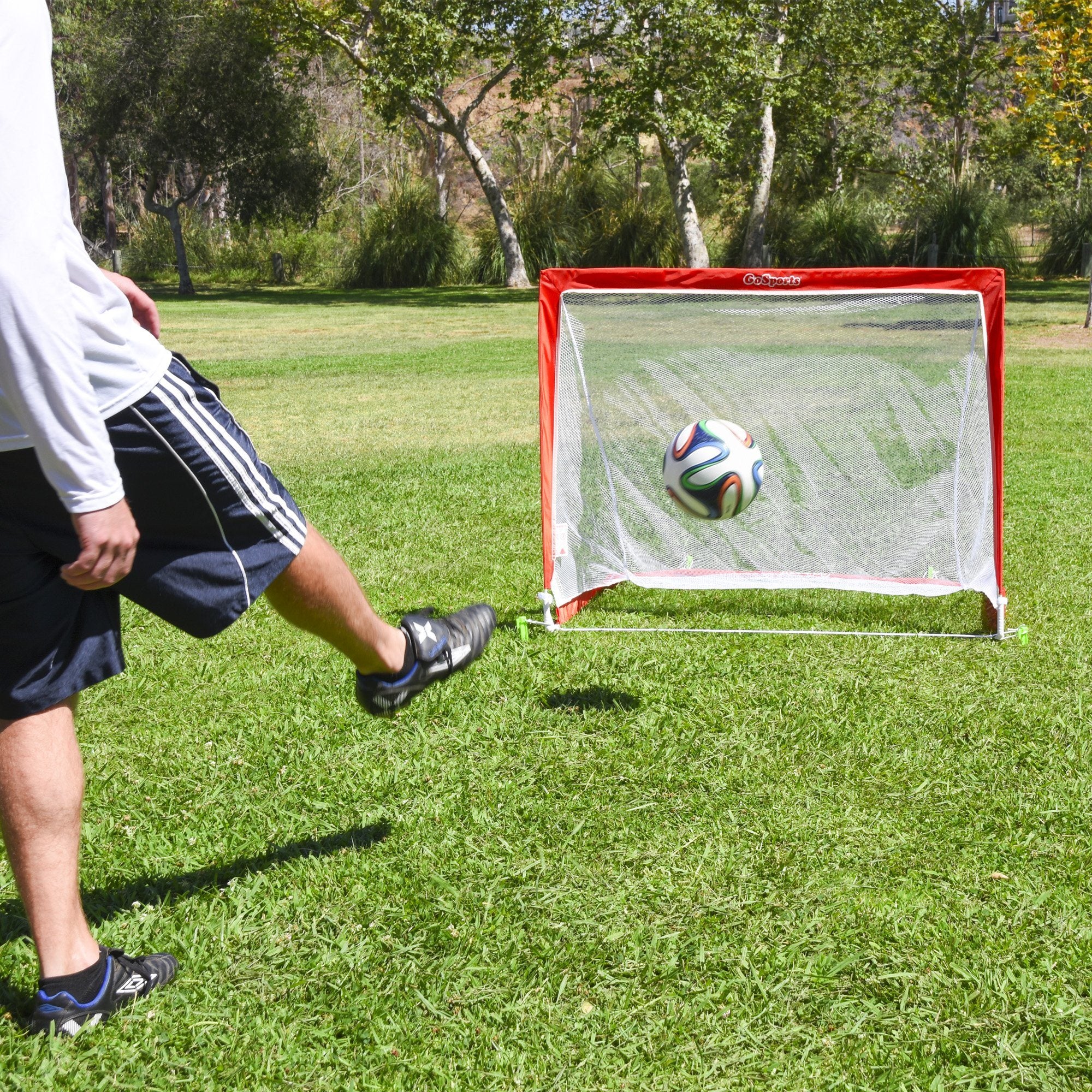 a man kicking a soccer ball in a field