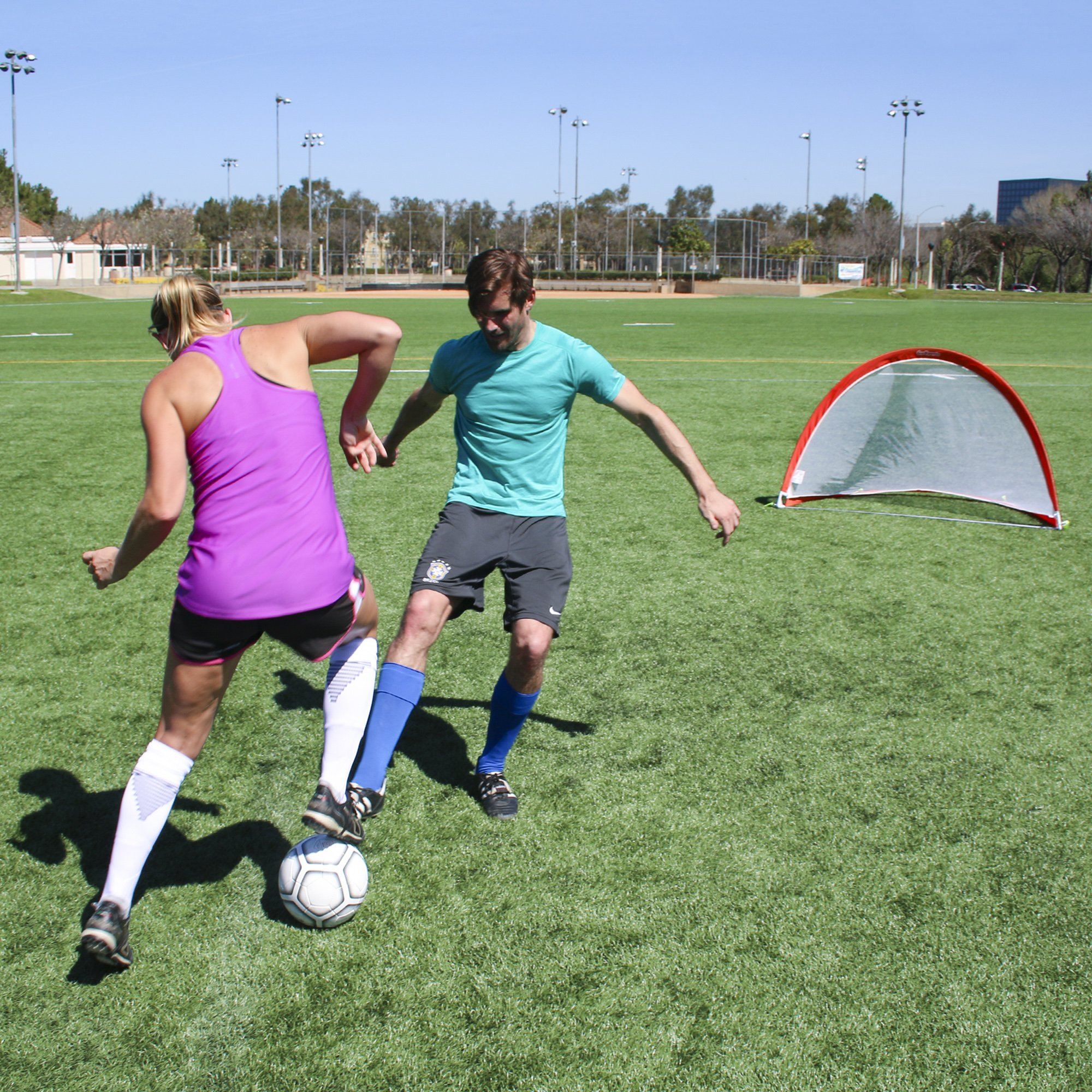 a man and woman playing soccer on a field