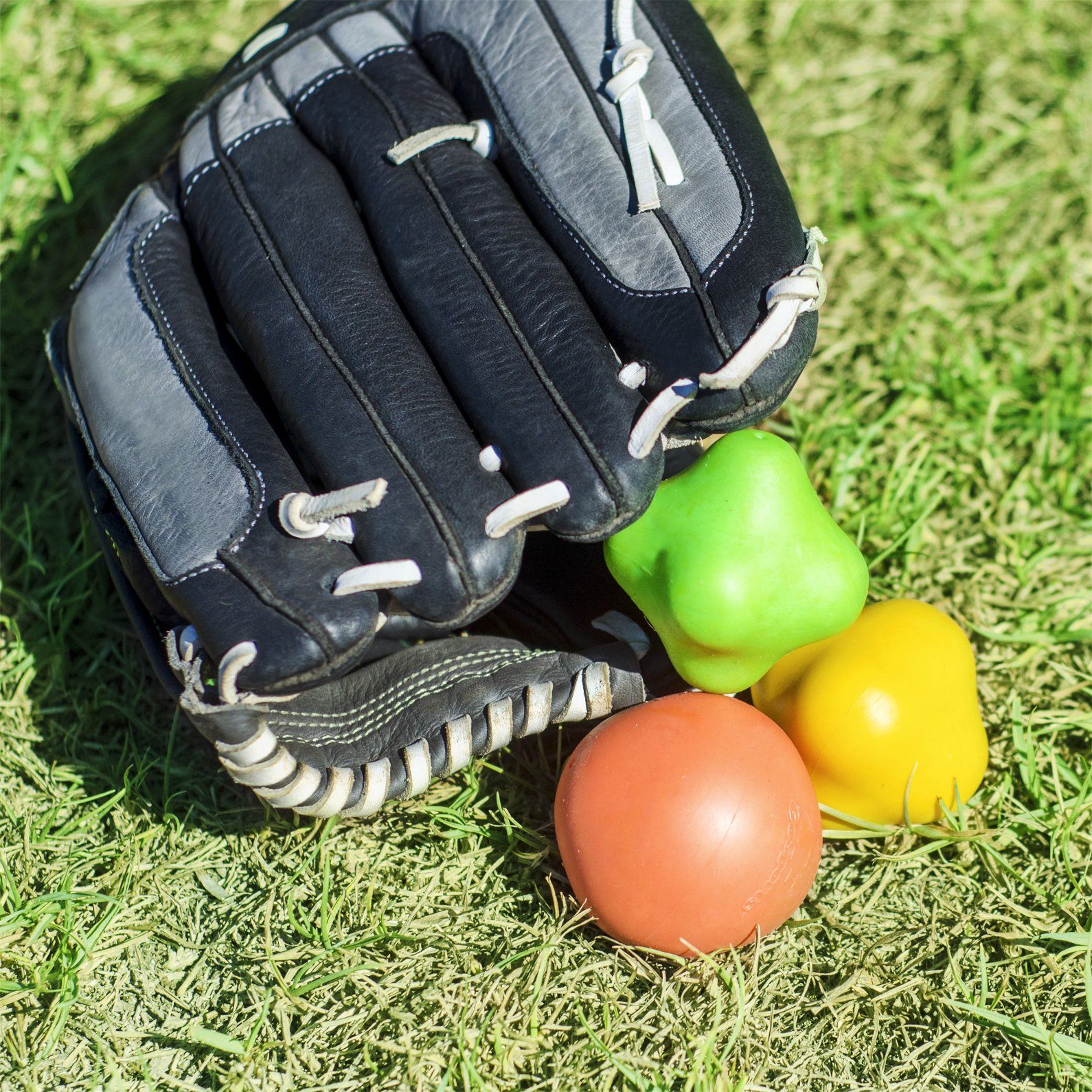 a baseball glove and ball on the grass