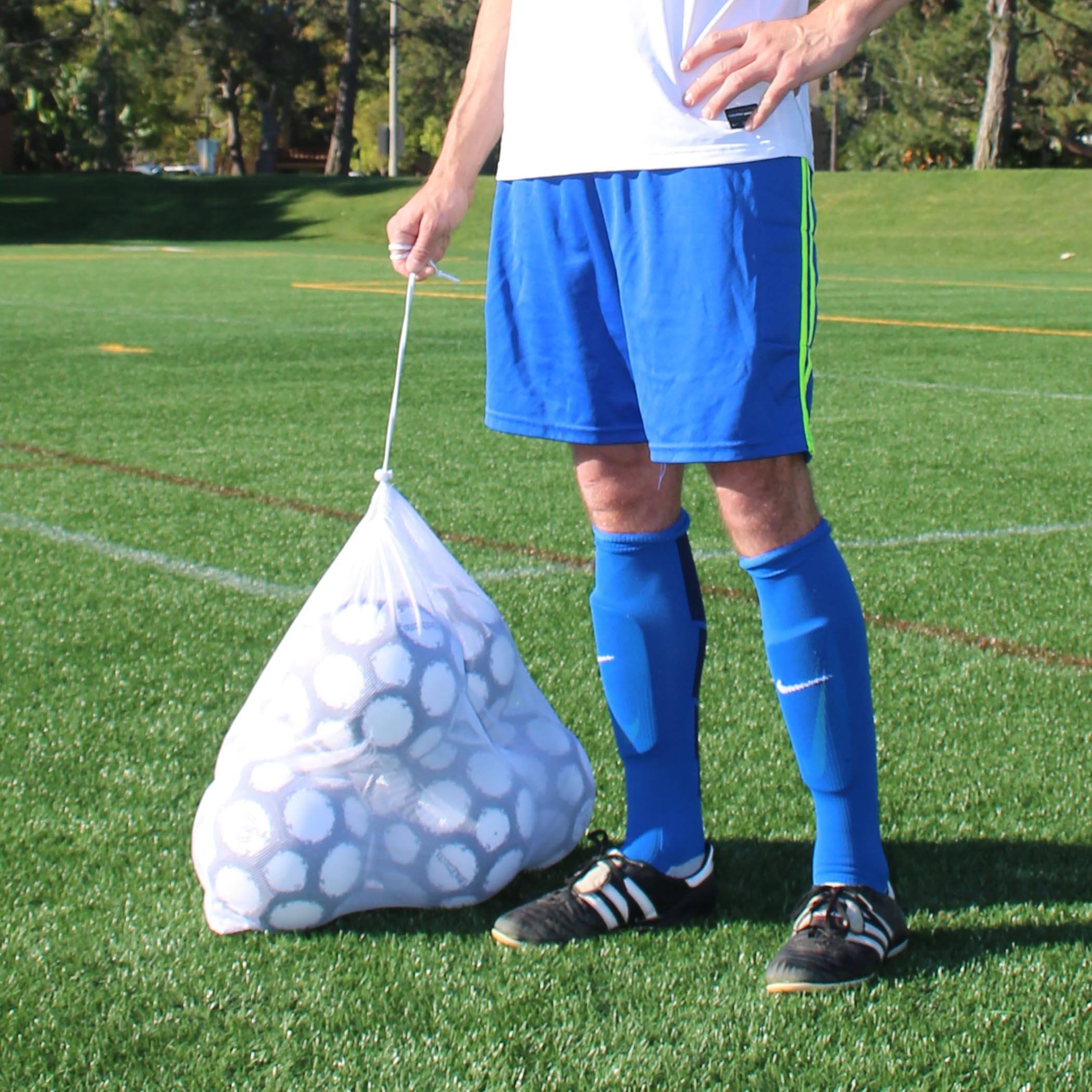 a man holding a bag of soccer balls