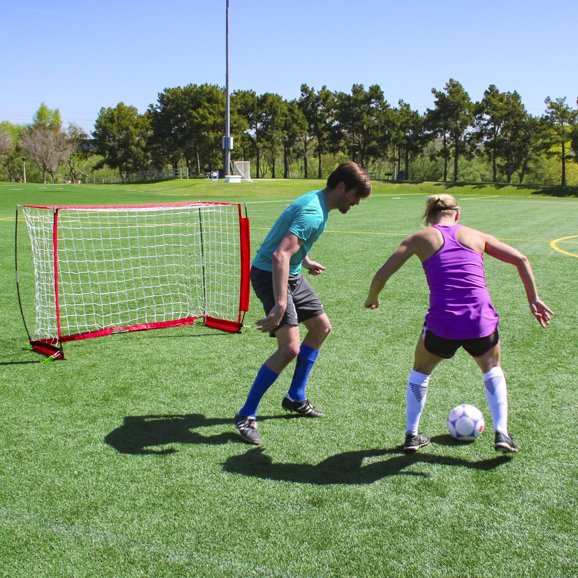a couple of people playing soccer on a field