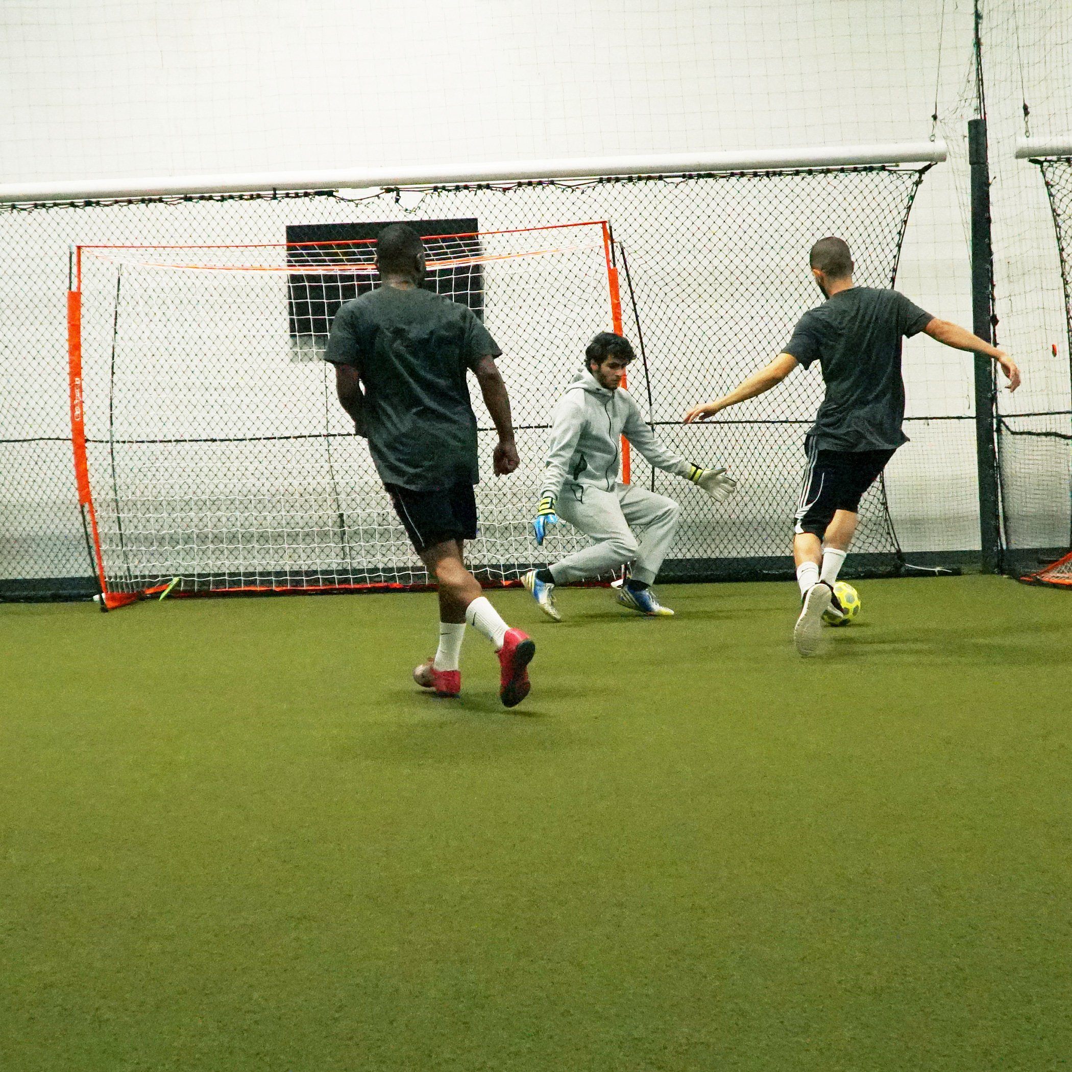 a group of men playing soccer in a soccer field