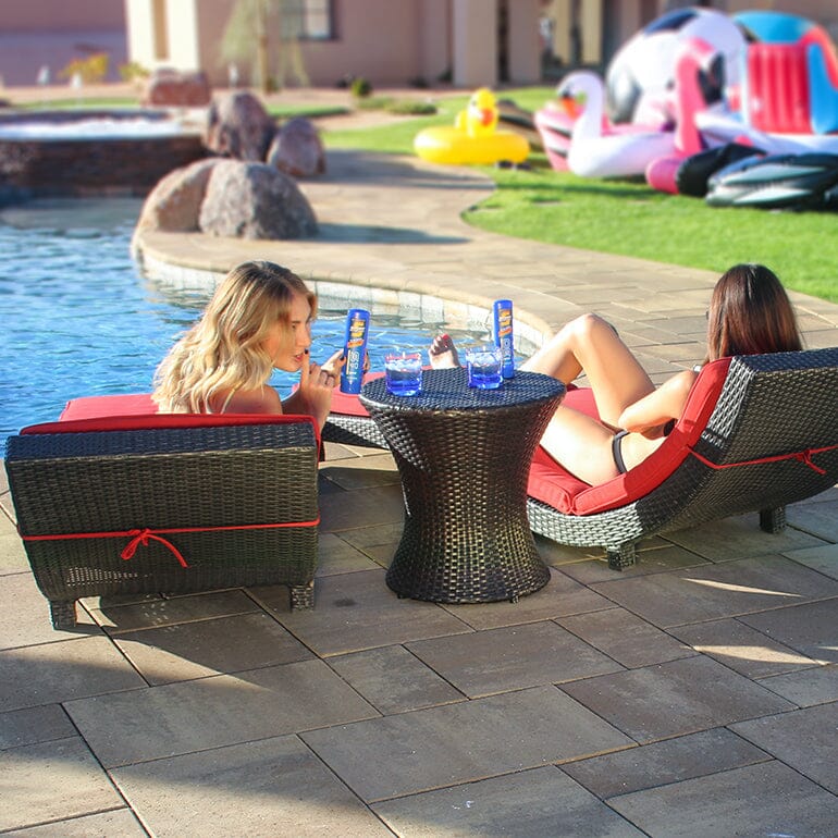 two women sitting at a table by a pool