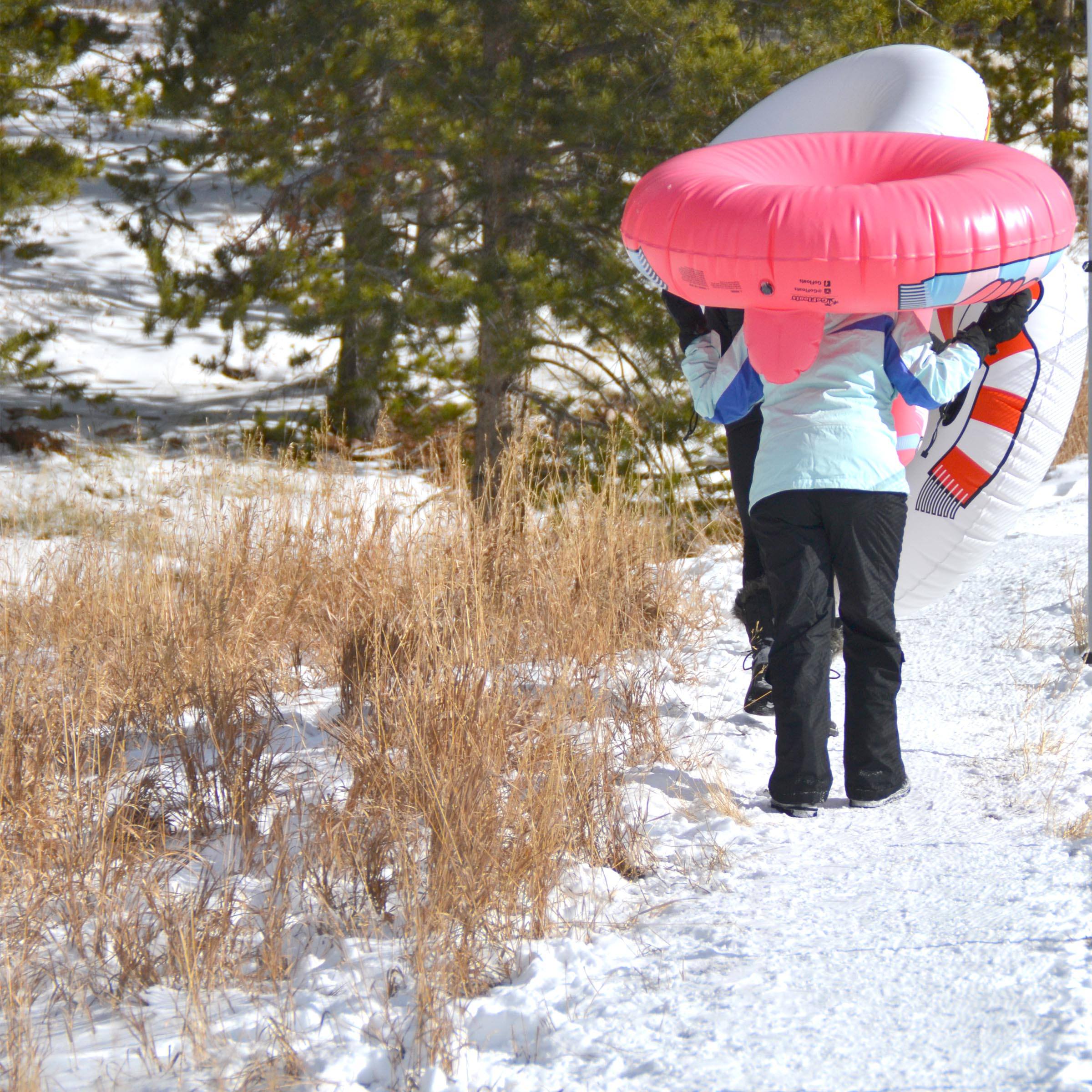 a woman walking in the snow with a pink umbrella
