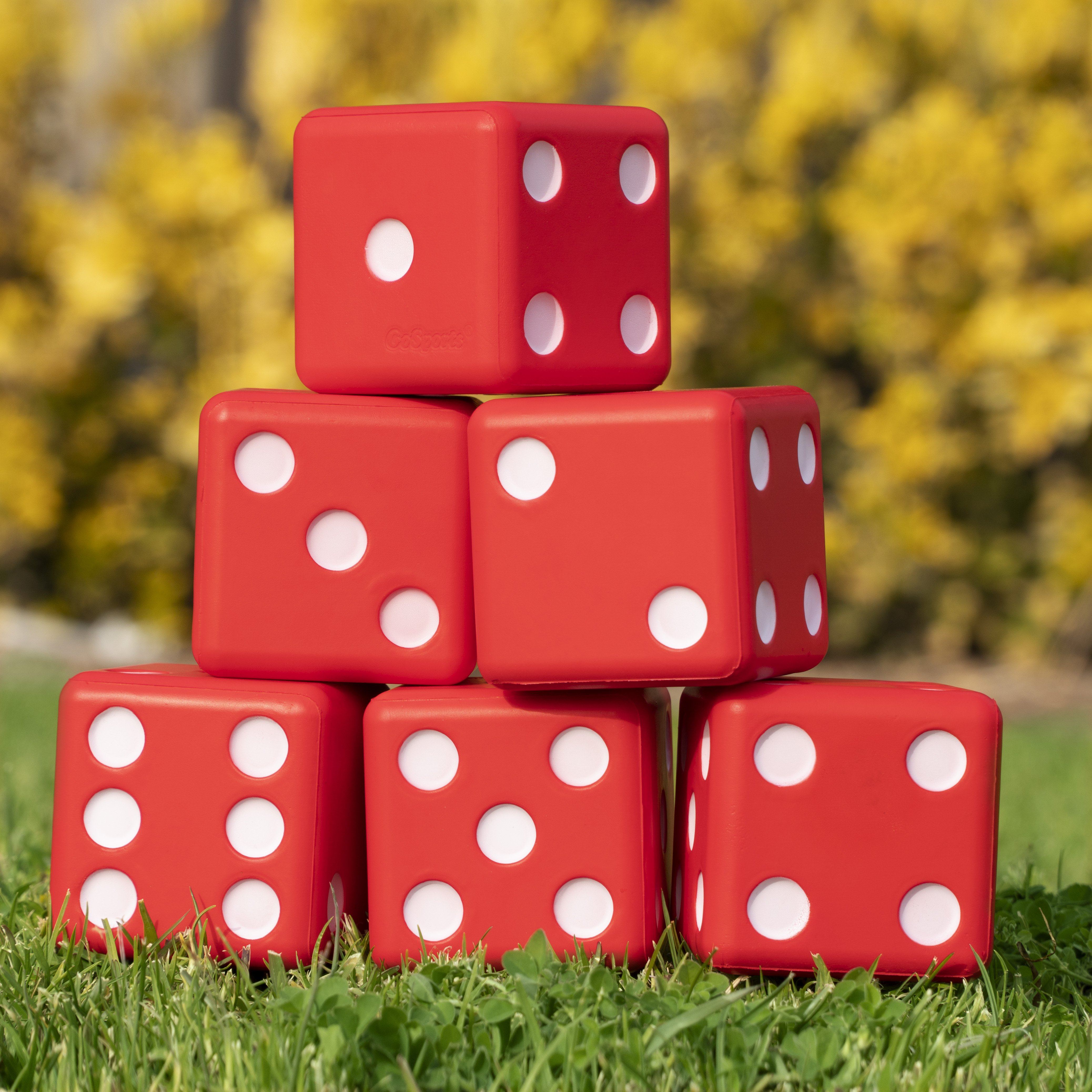 a pile of red dice sitting on top of a green field