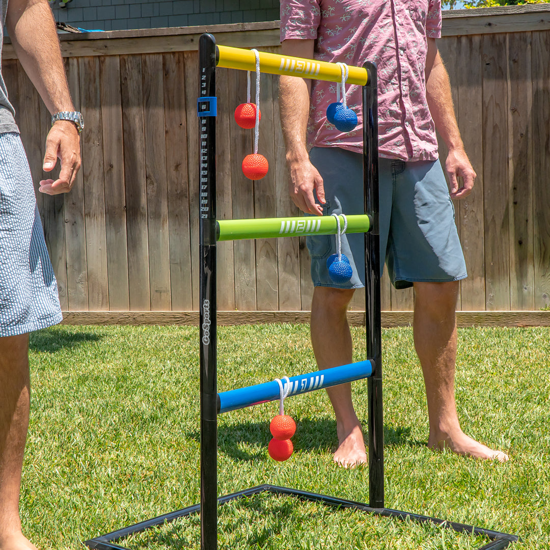 Two people playing with a ladder ball game on grass