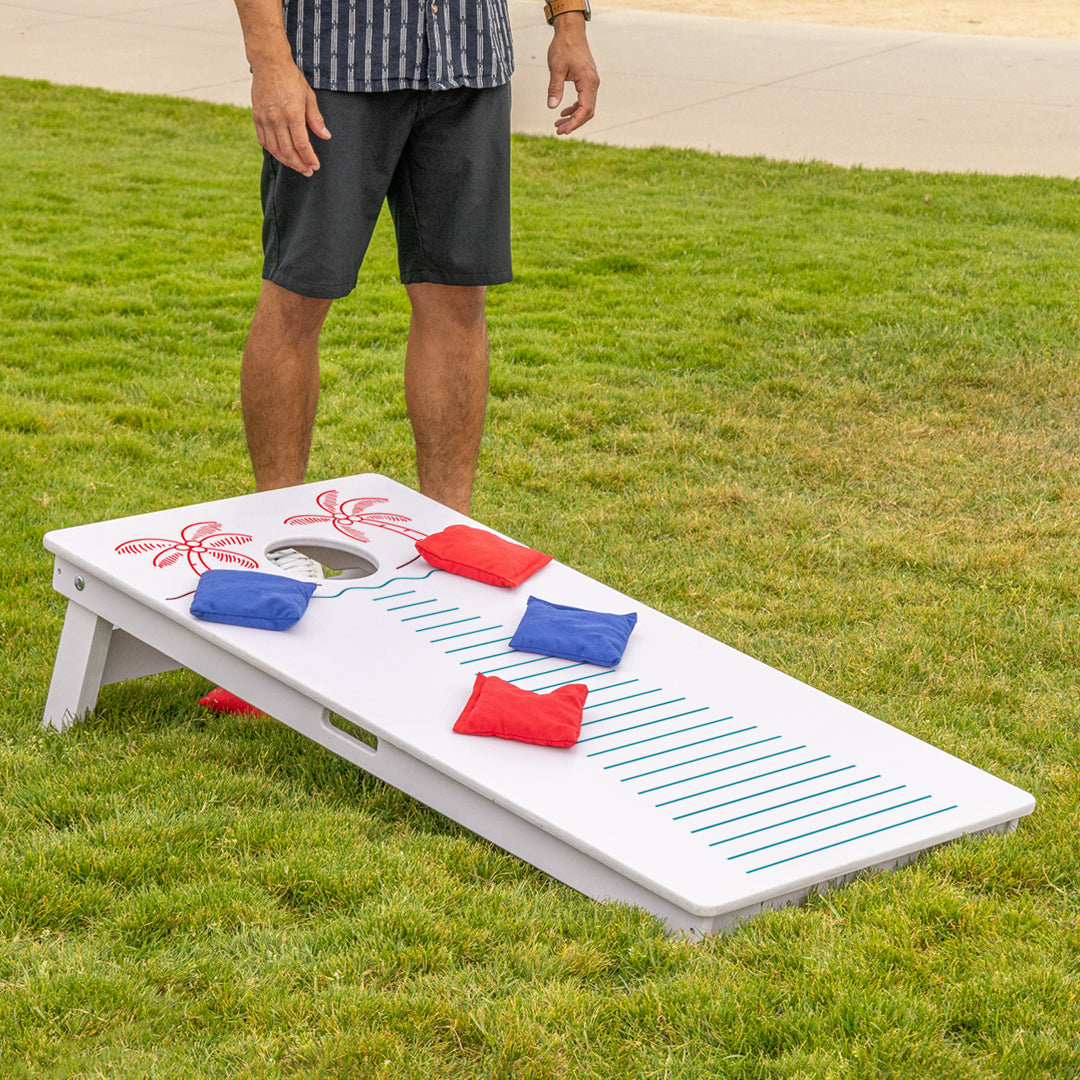 Cornhole board with colorful bags on a grassy outdoor setting