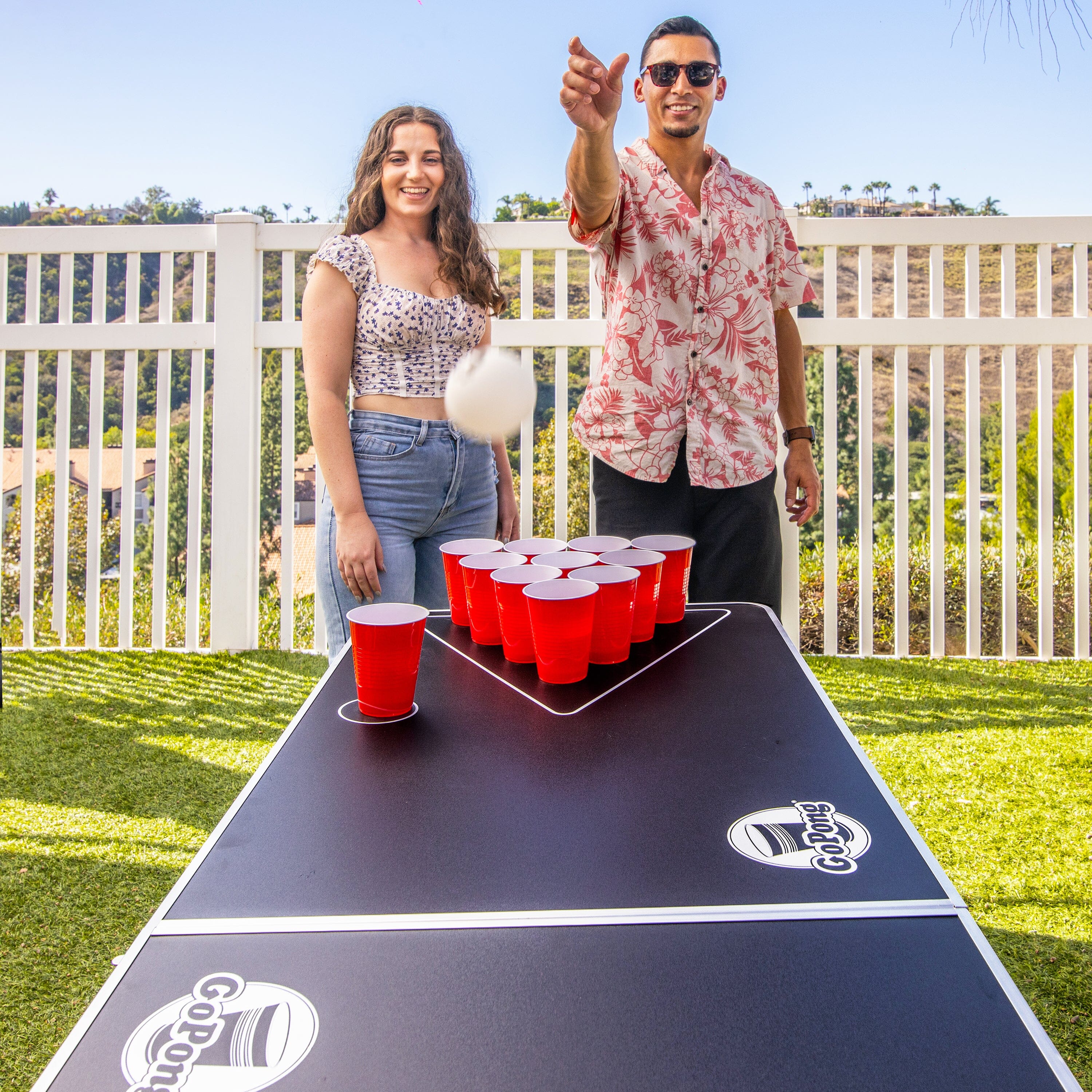 a man and woman playing a game of beer pong