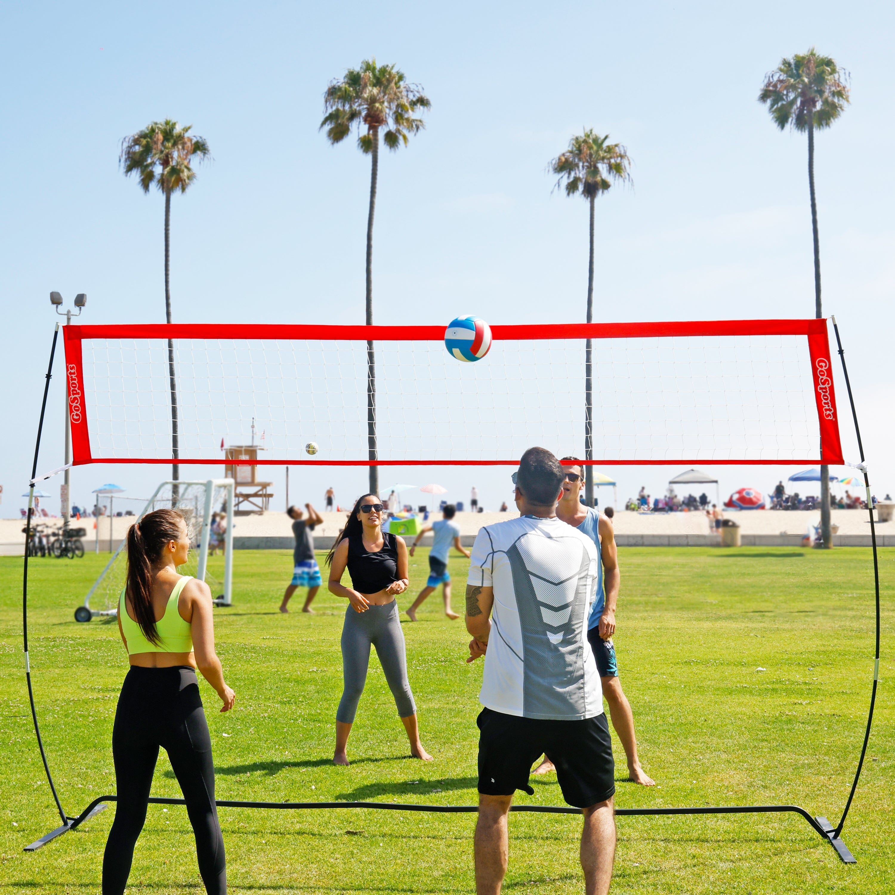 a group of people playing volleyball on a field