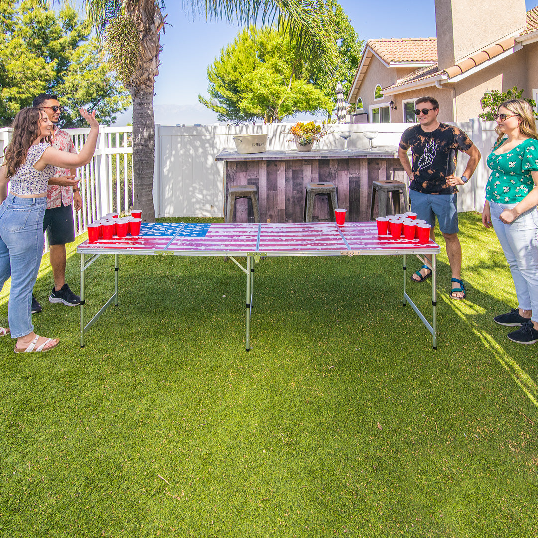 People playing beer pong in a backyard setting