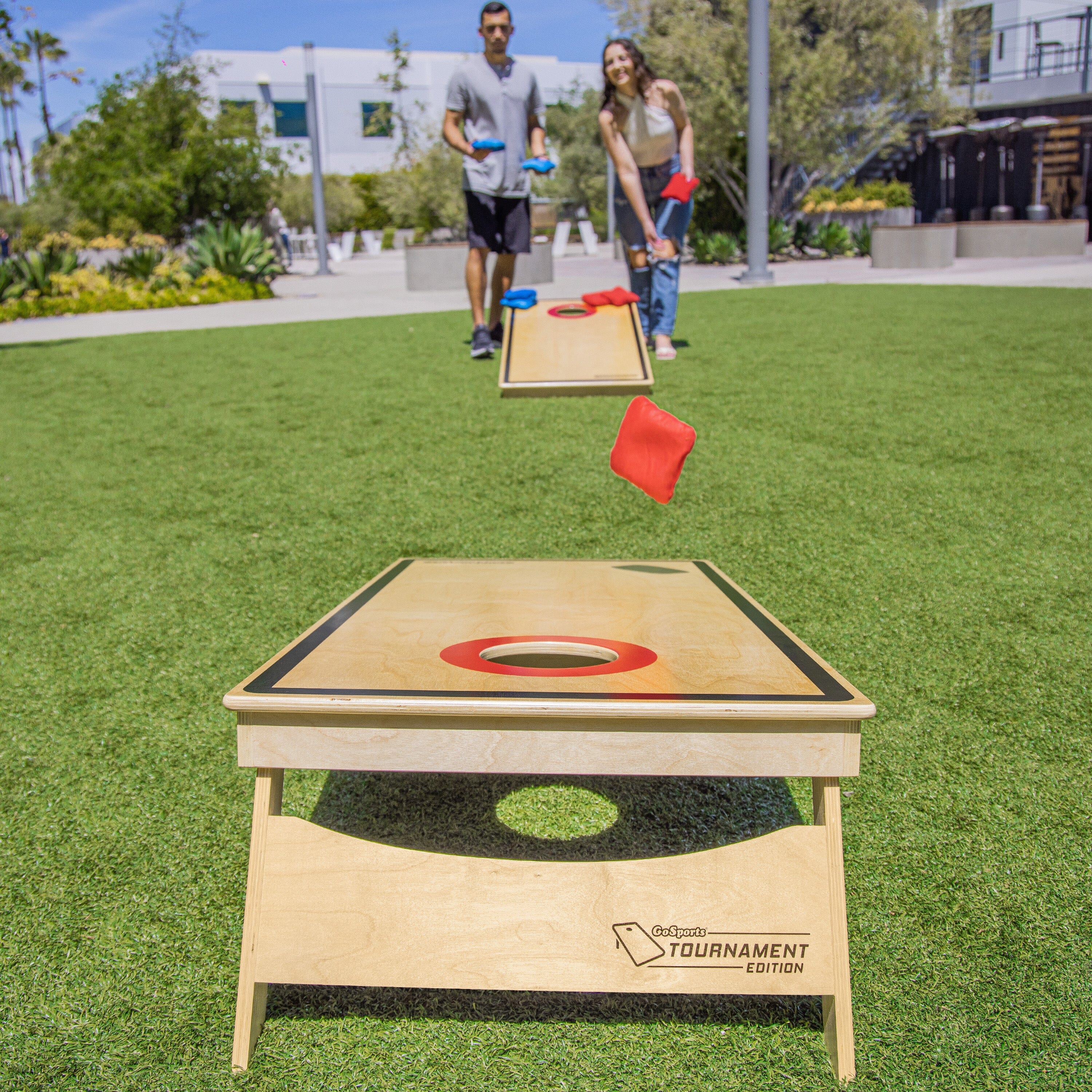 a man and woman playing cornhole game