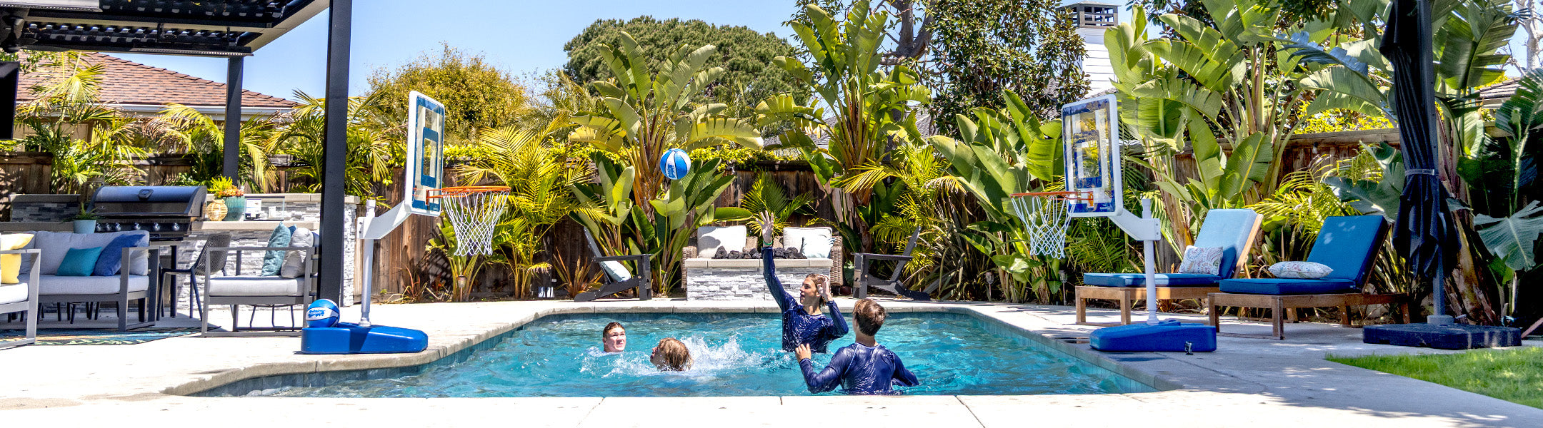 Children playing in a pool with toys and a basketball hoop in a backyard setting.