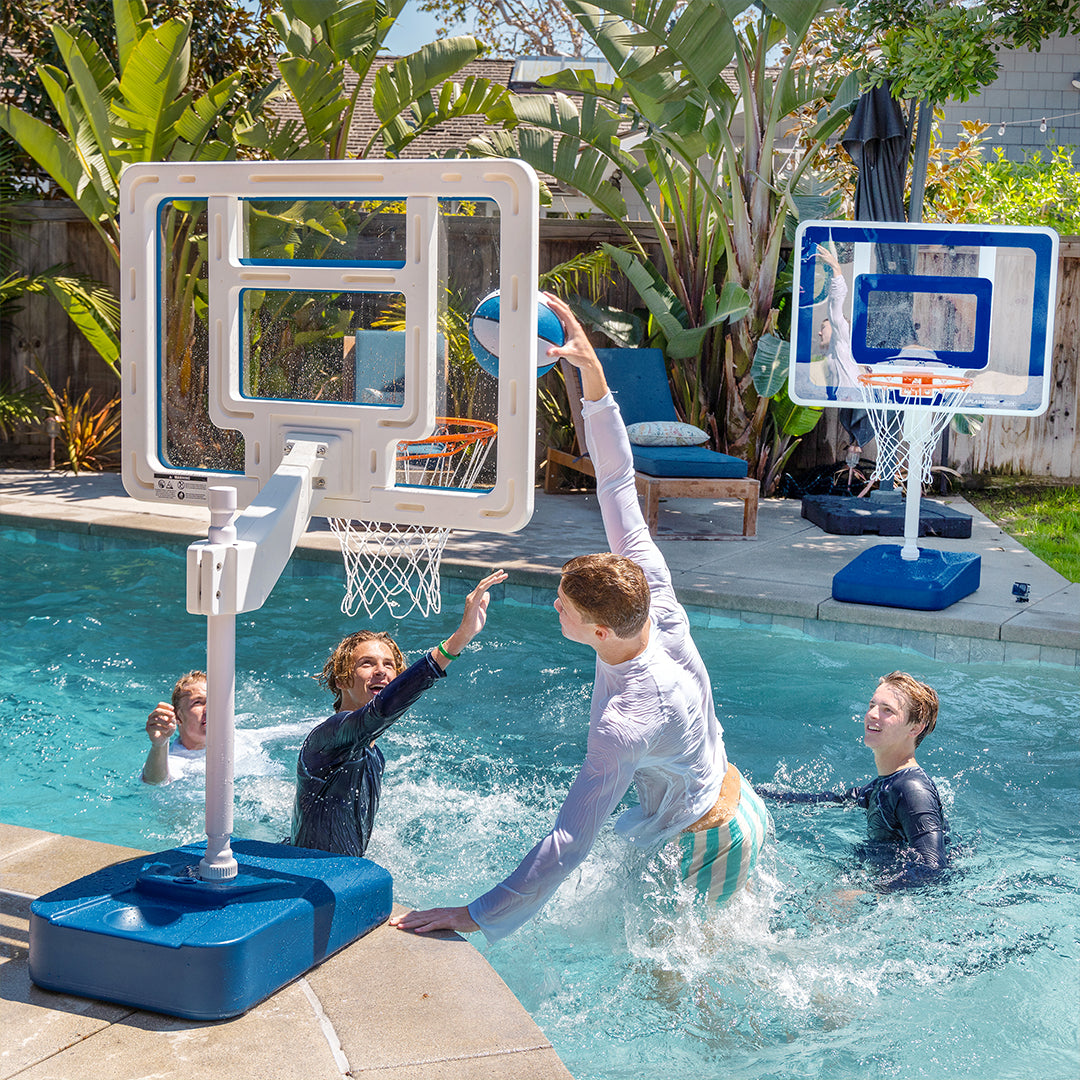 Children playing basketball in a pool with a poolside basketball hoop