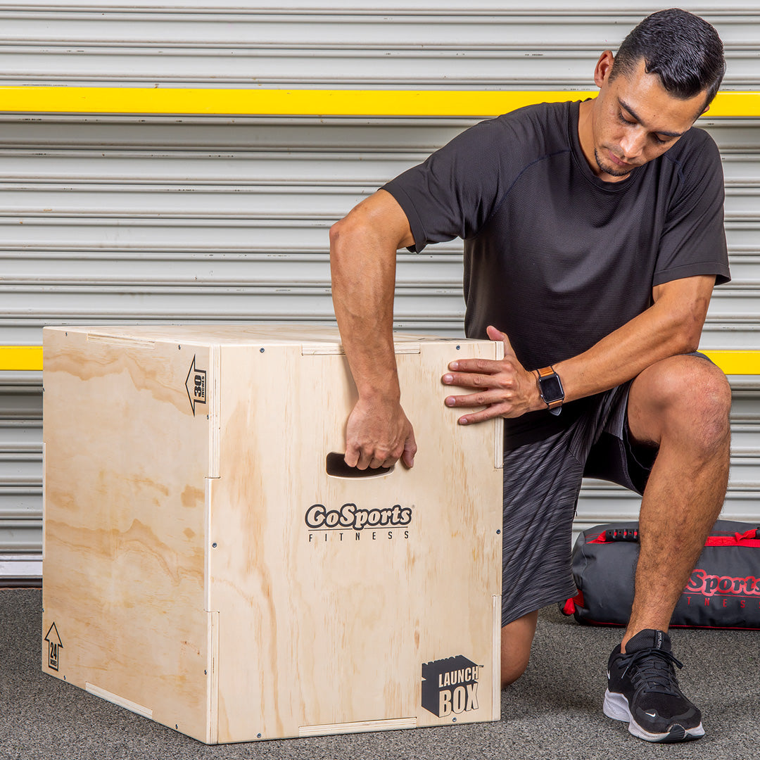 Man using a GoSports fitness box in front of a garage door