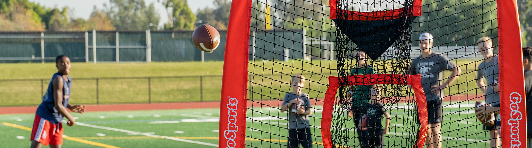 Children playing with a football and goalpost on a sports field