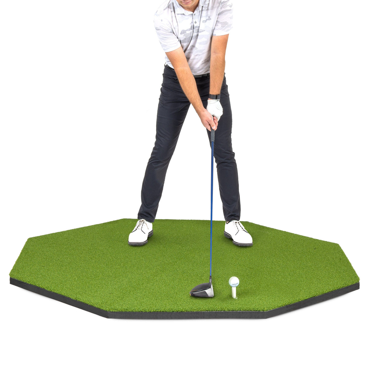 GoSports 5x5 ft octagon golf hitting mat, green turf on black foam, with a golfer at address over a ball on a white tee